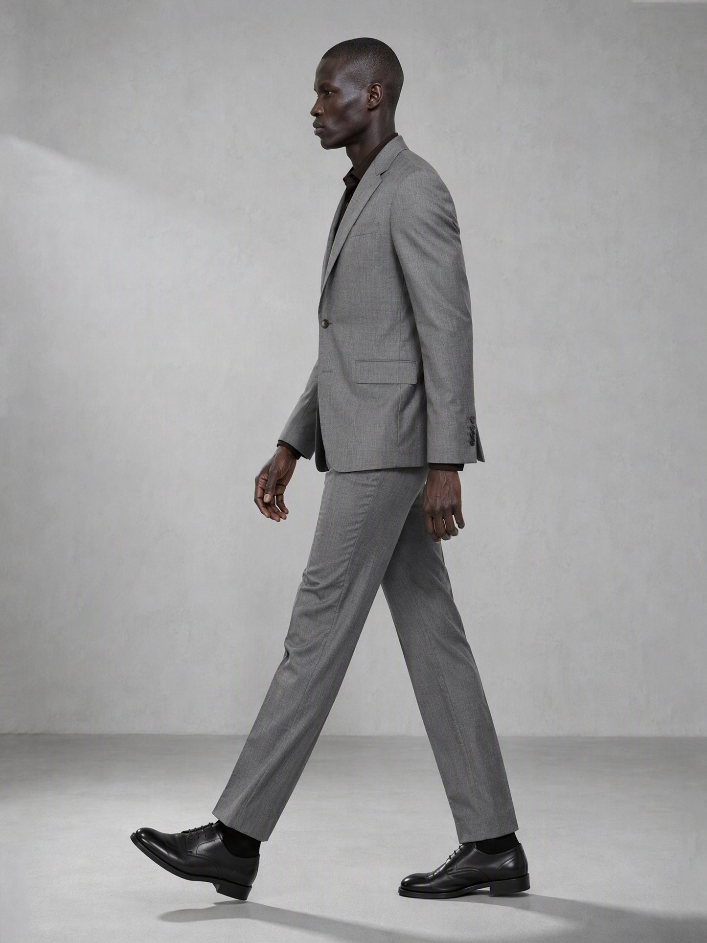 Savile grey wool blend suit – back view showing center vent, structured shoulder and clean tapered trouser silhouette