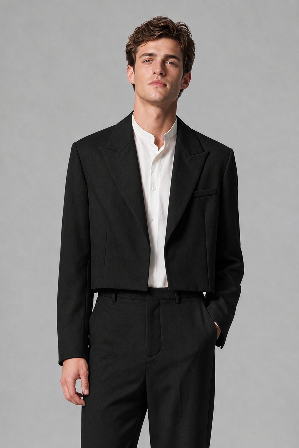 Close-up front view of the Savile cropped black peak-lapel blazer with long sleeves and welt chest pocket