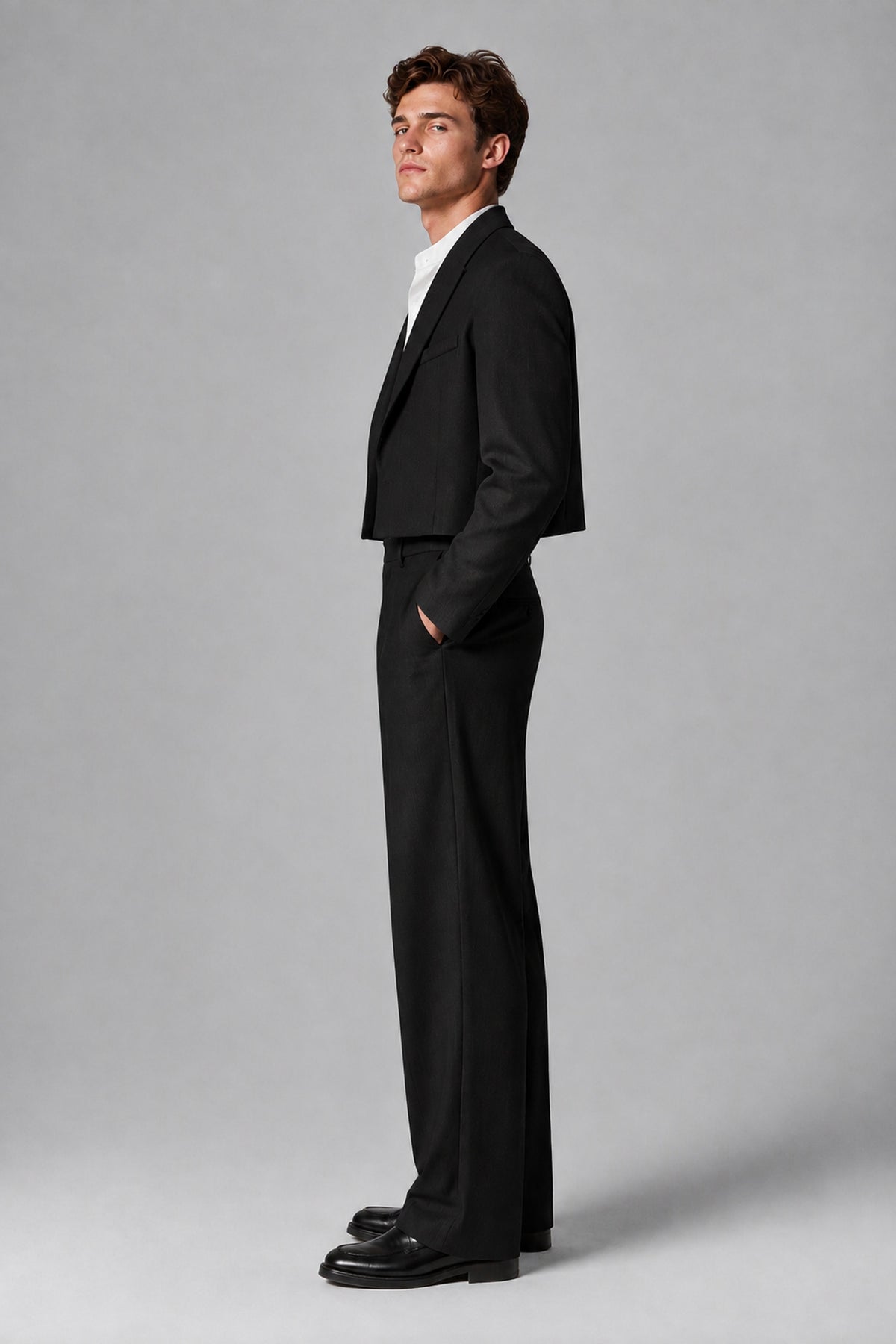 Side profile view of the Savile black cropped blazer and pleated wide-leg trousers
