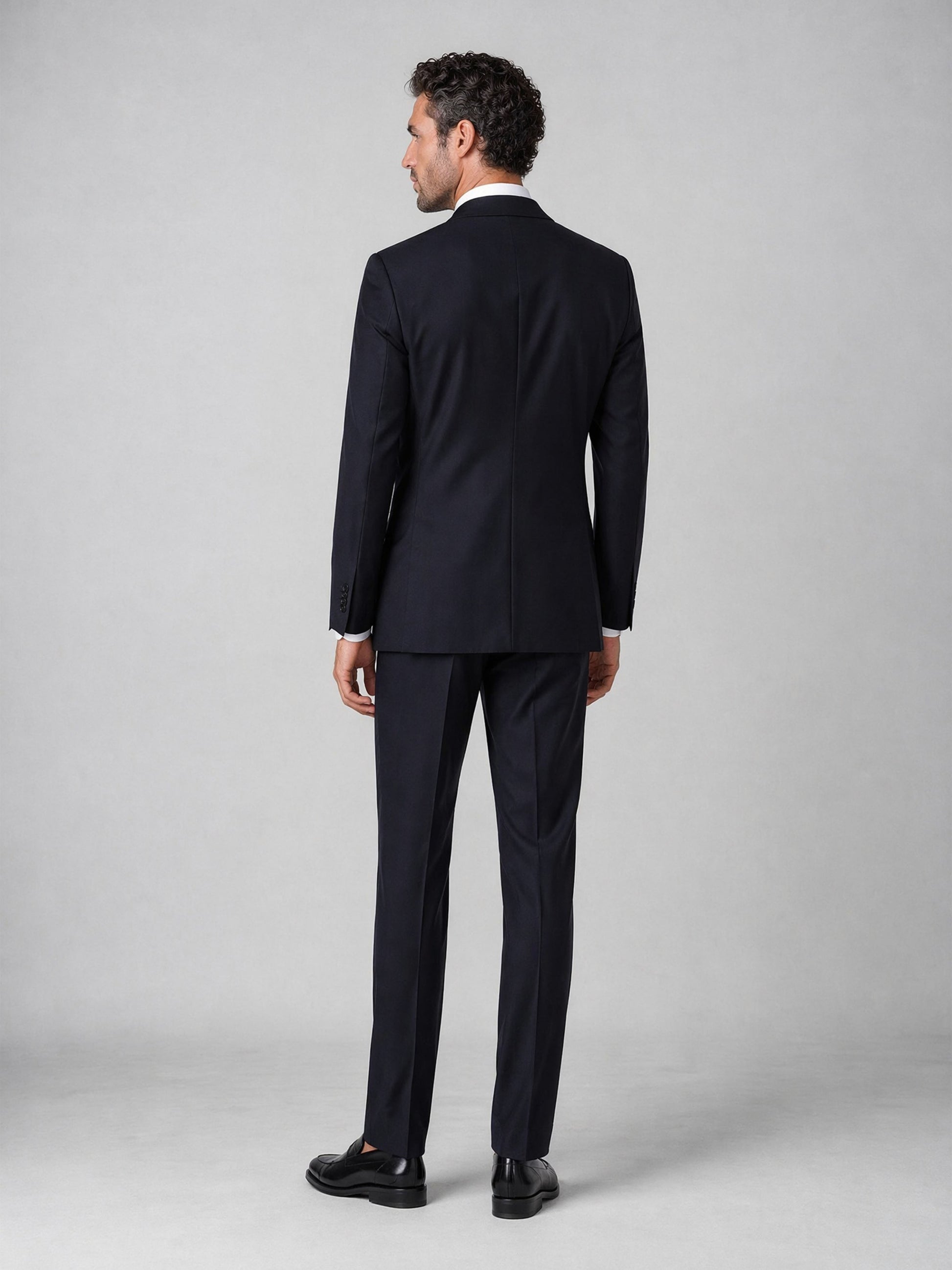 Men's navy double-breasted suit - back view showing jacket cut and full-length trouser