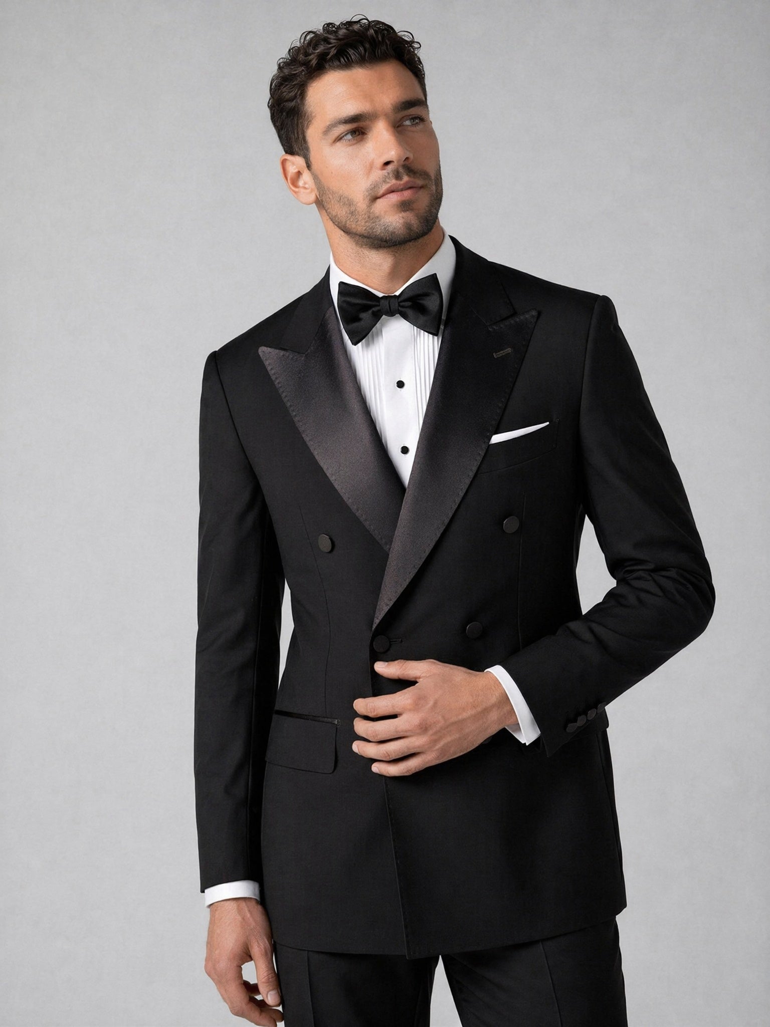 Men's black tuxedo suit - upper body close up showing satin peak lapel and six-button detail