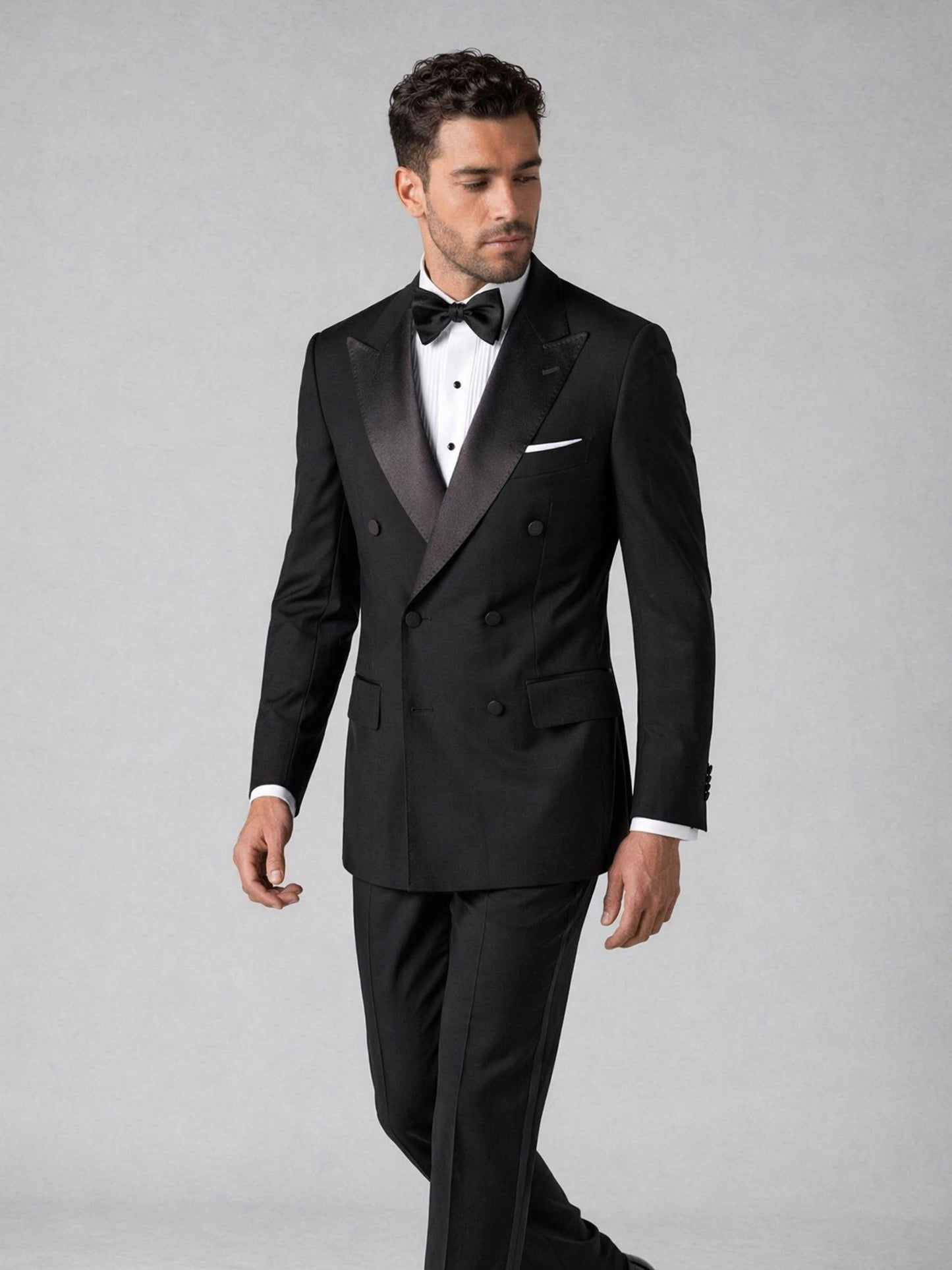 Men's black tuxedo suit - walking pose showing slim fit silhouette and trouser length