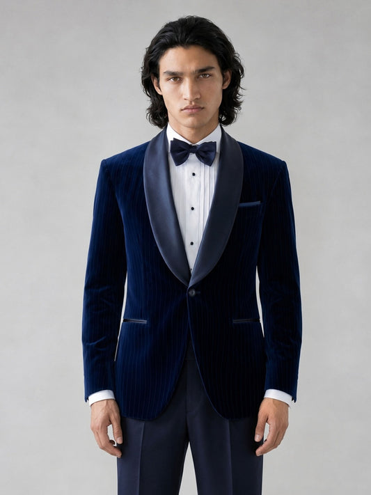 Savile GA0062 navy velvet tuxedo – three-quarter side pose, model adjusting bow tie showing relaxed confidence