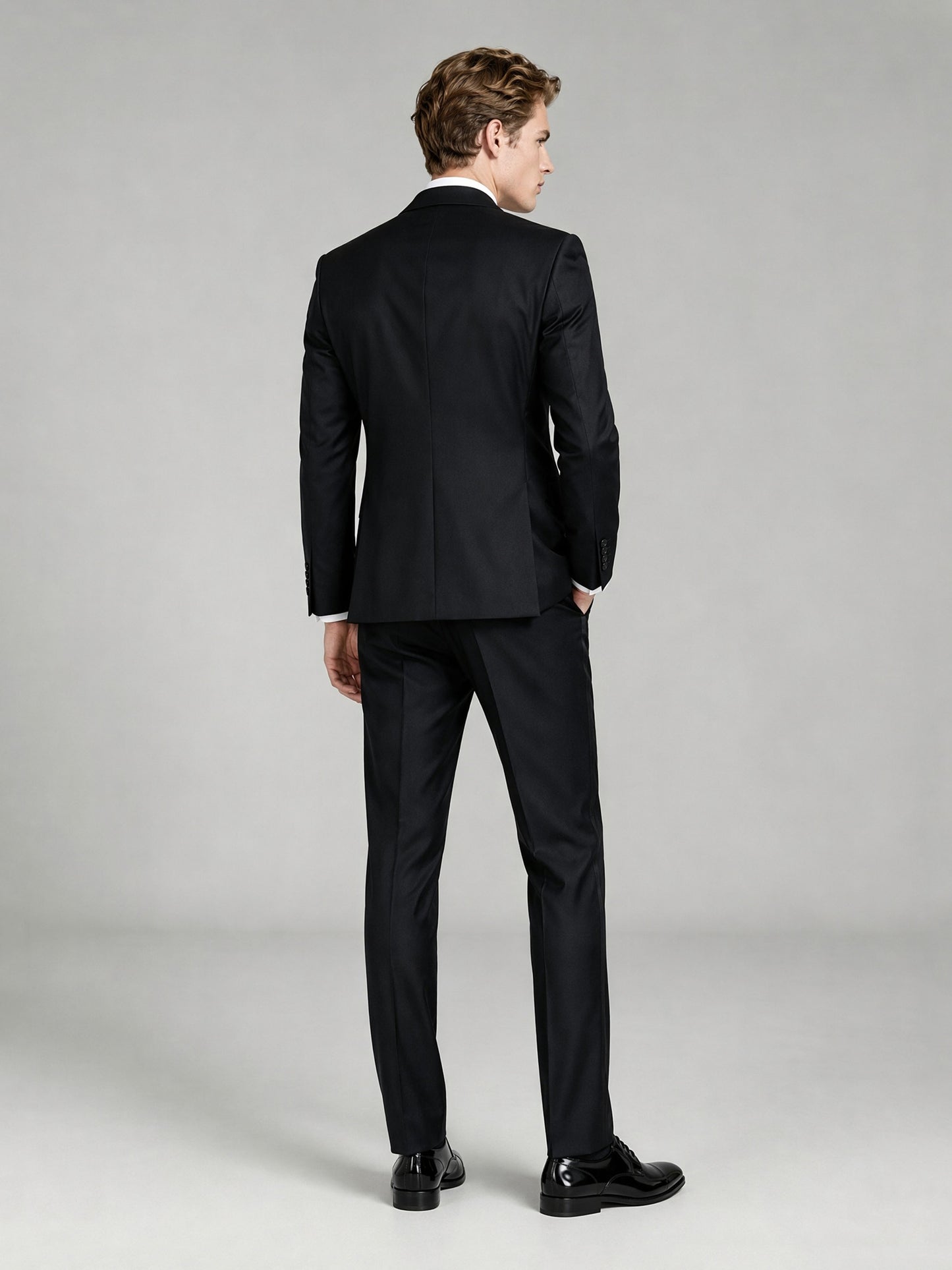 Savile GA0065 black peak lapel tuxedo set – full body front view, hands clasped showing slim silhouette and satin lapel detail