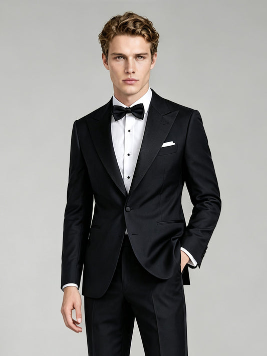 Savile GA0065 black peak lapel tuxedo – full body front view, hand touching lapel showing confident black-tie styling