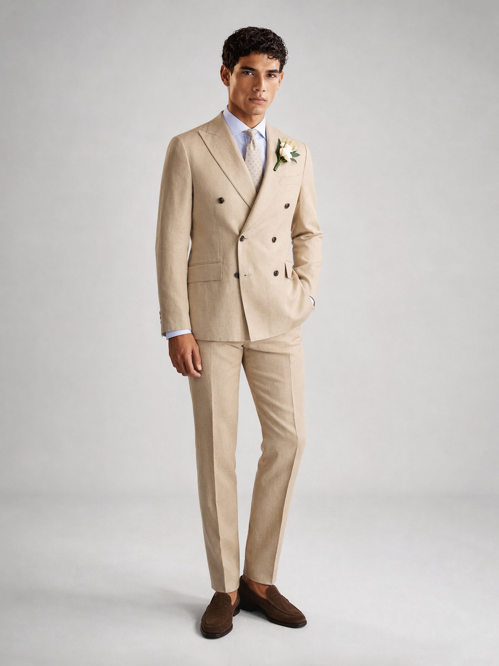 Savile GA0071 sand camel linen double-breasted suit – upper body front view showing peak lapel, six-button closure, white shirt, light blue tie and white boutonnière