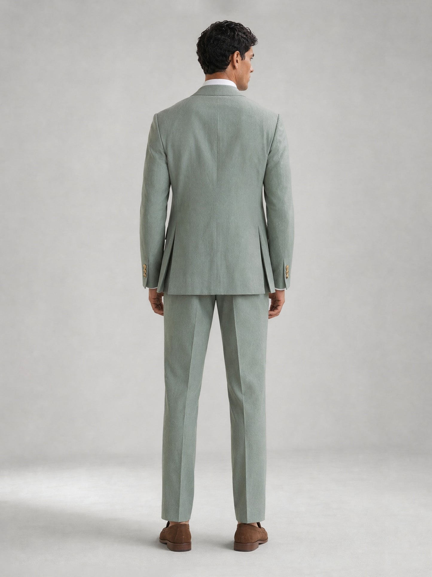 Savile GA0074 mint green double-breasted suit – full body three-quarter pose, hand touching lapel showing Italian drape and slim trouser silhouette