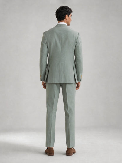 Savile GA0074 mint green double-breasted suit – full body three-quarter pose, hand touching lapel showing Italian drape and slim trouser silhouette