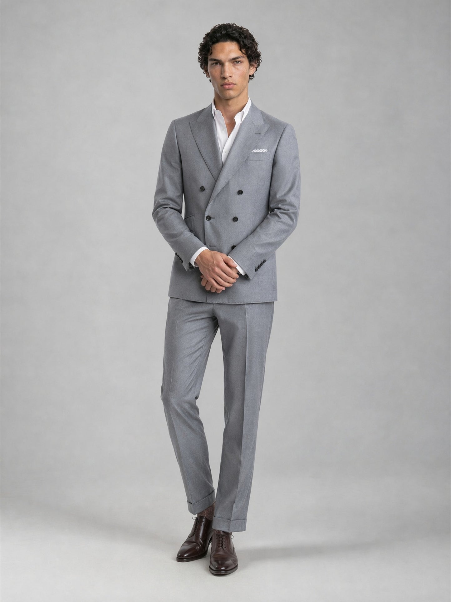 Savile GA0078 mid grey double-breasted 2-piece suit – full body front view, hands clasped showing slim silhouette and turn-up trouser cuffs