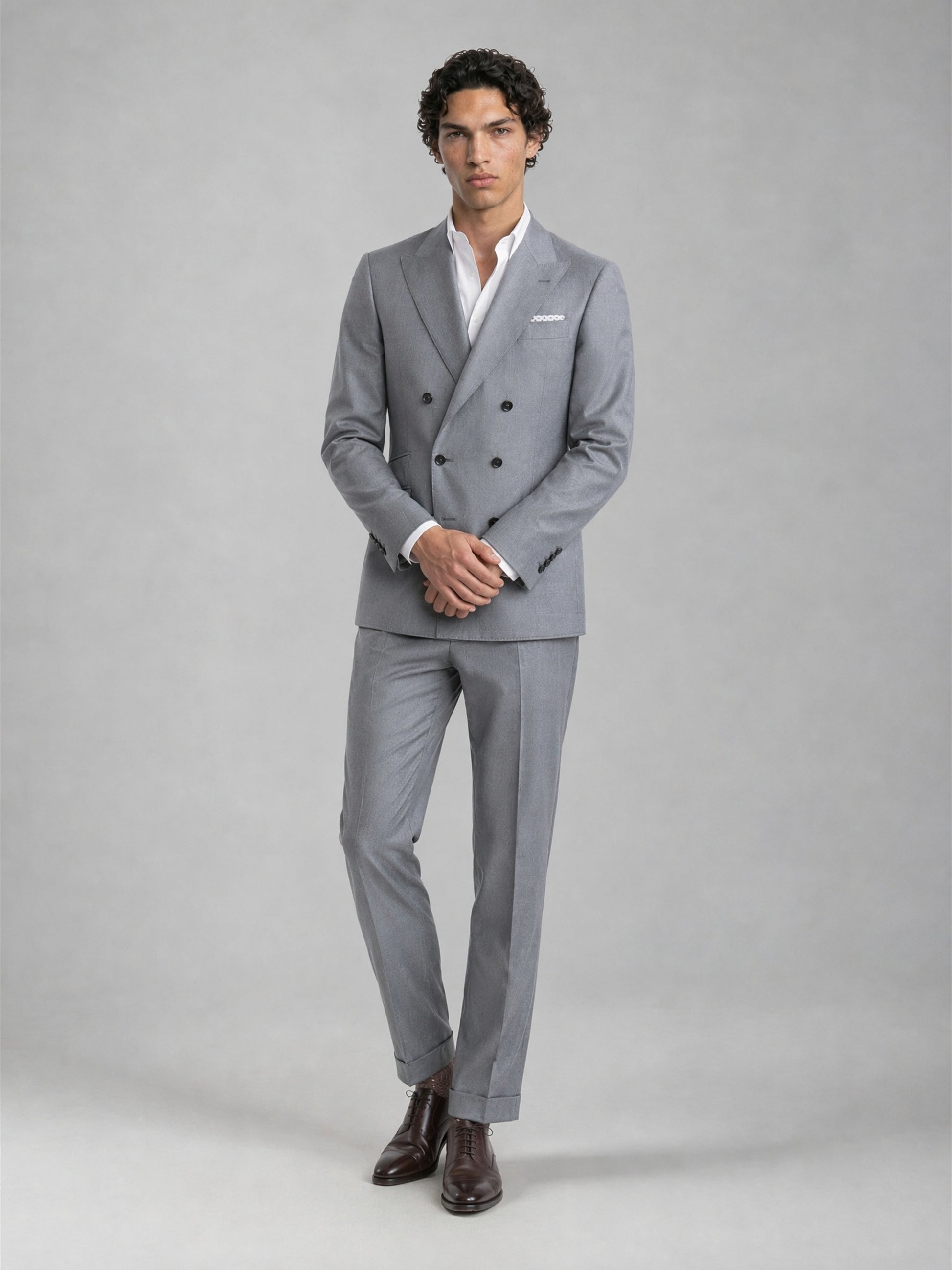 Savile GA0078 mid grey double-breasted 2-piece suit – full body front view, hands clasped showing slim silhouette and turn-up trouser cuffs