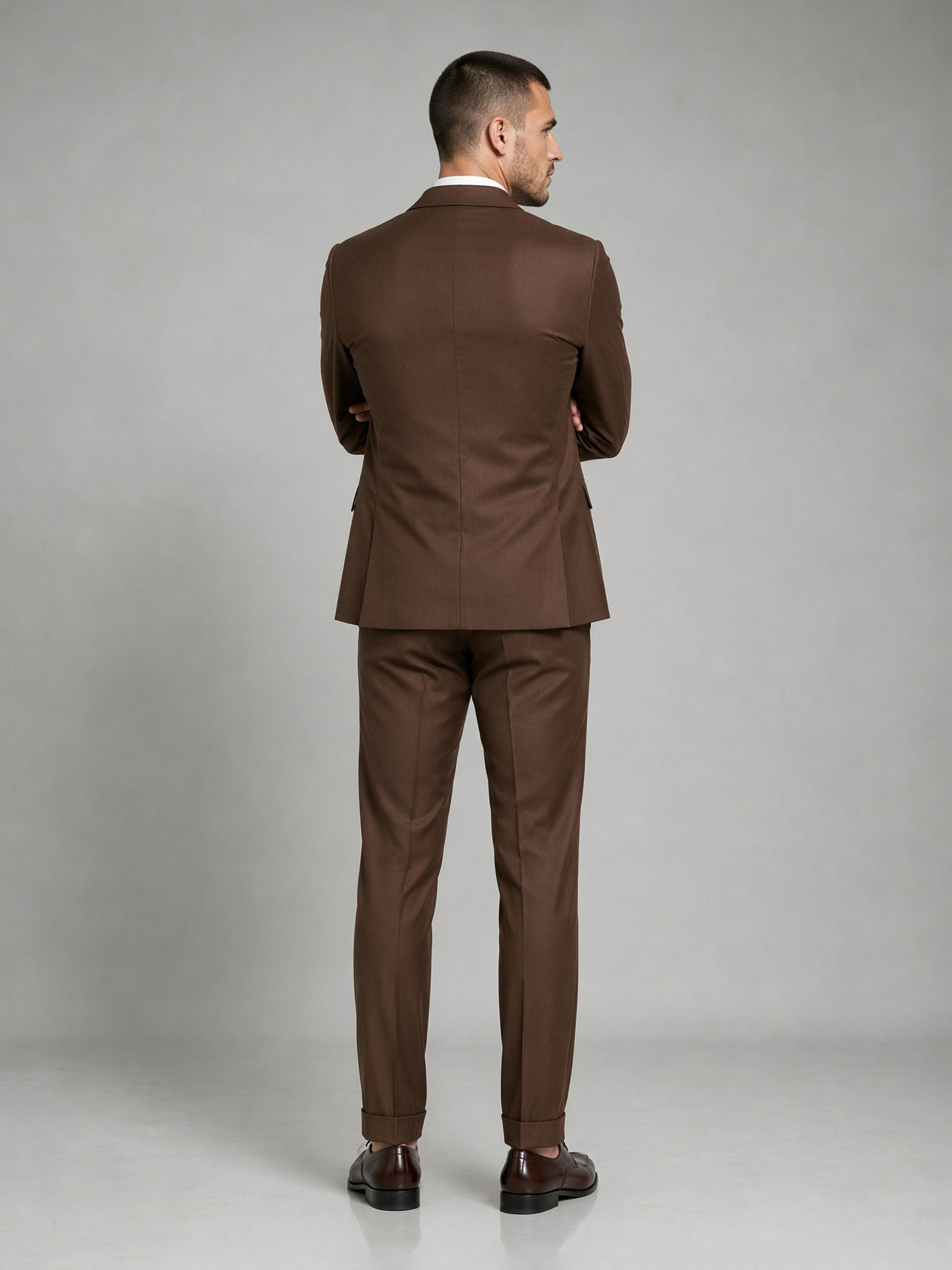 Savile GA0083 chocolate brown wool suit – full body front view, hand in pocket with dark brown brogue oxfords showing slim silhouette and turn-up cuffs