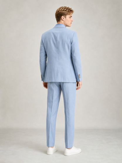 Savile GA0084 ice blue linen suit – full body front view, arms crossed leaning against wall showing Italian drape and slim trouser silhouette