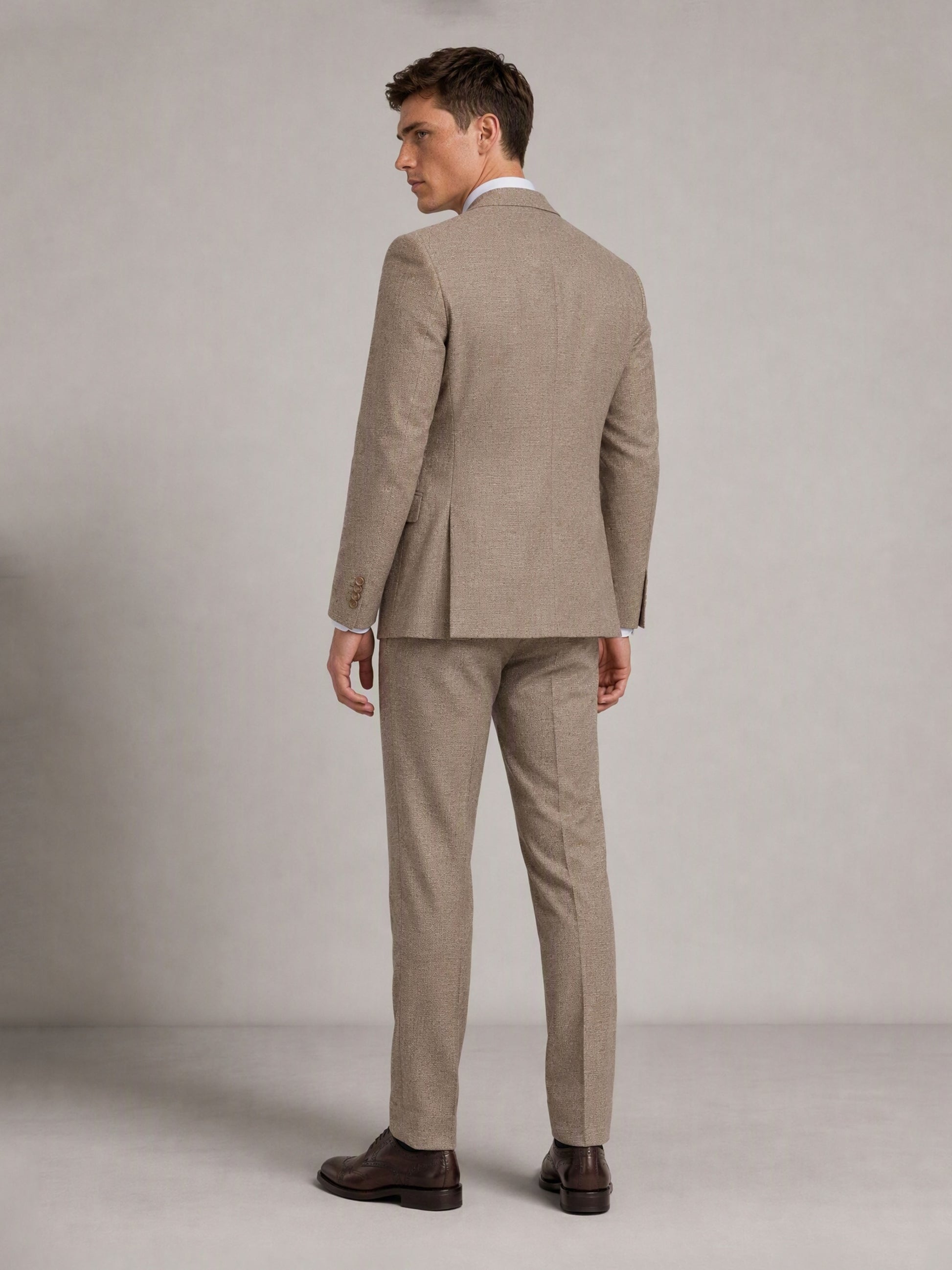 Savile GA0091 warm sand check suit – full body front view, hand touching lapel showing waistcoat layering, notch lapel profile and slim trouser silhouette