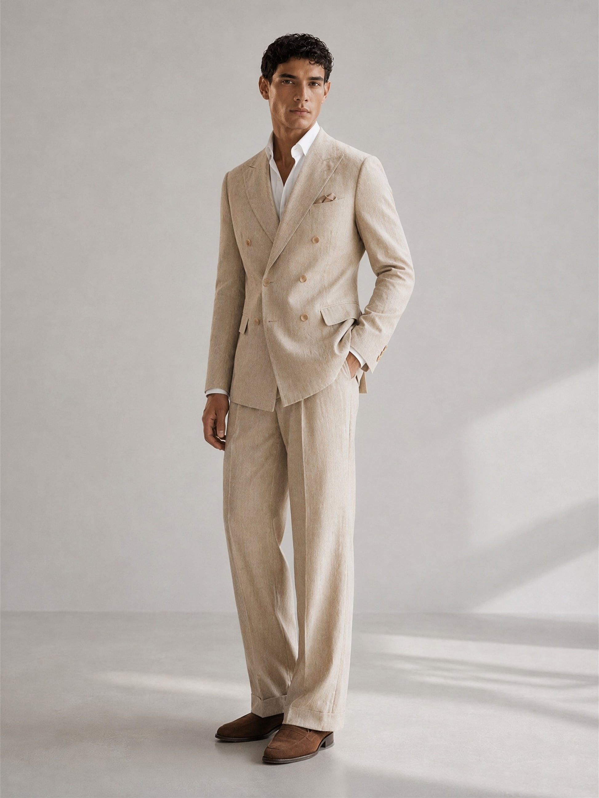 Savile GA0094 natural beige linen suit set – back view showing center vent, soft unpadded shoulders and wide-leg turn-up trouser drape with dark brown suede loafers