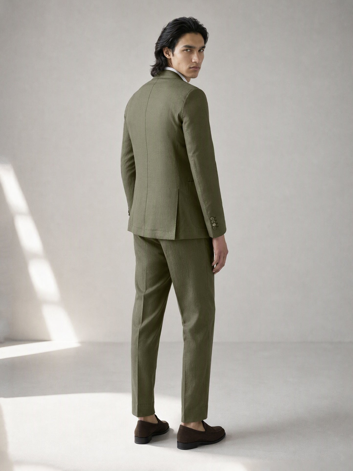 Savile olive green linen suit – back view, full length showing center vent and tapered trousers