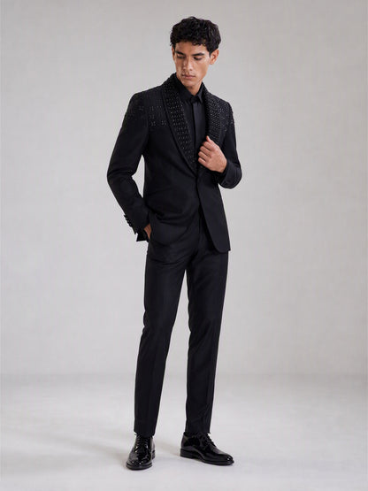 Savile black crystal shawl collar suit – full-length front view, hand at button showing crystal collar and clean body contrast