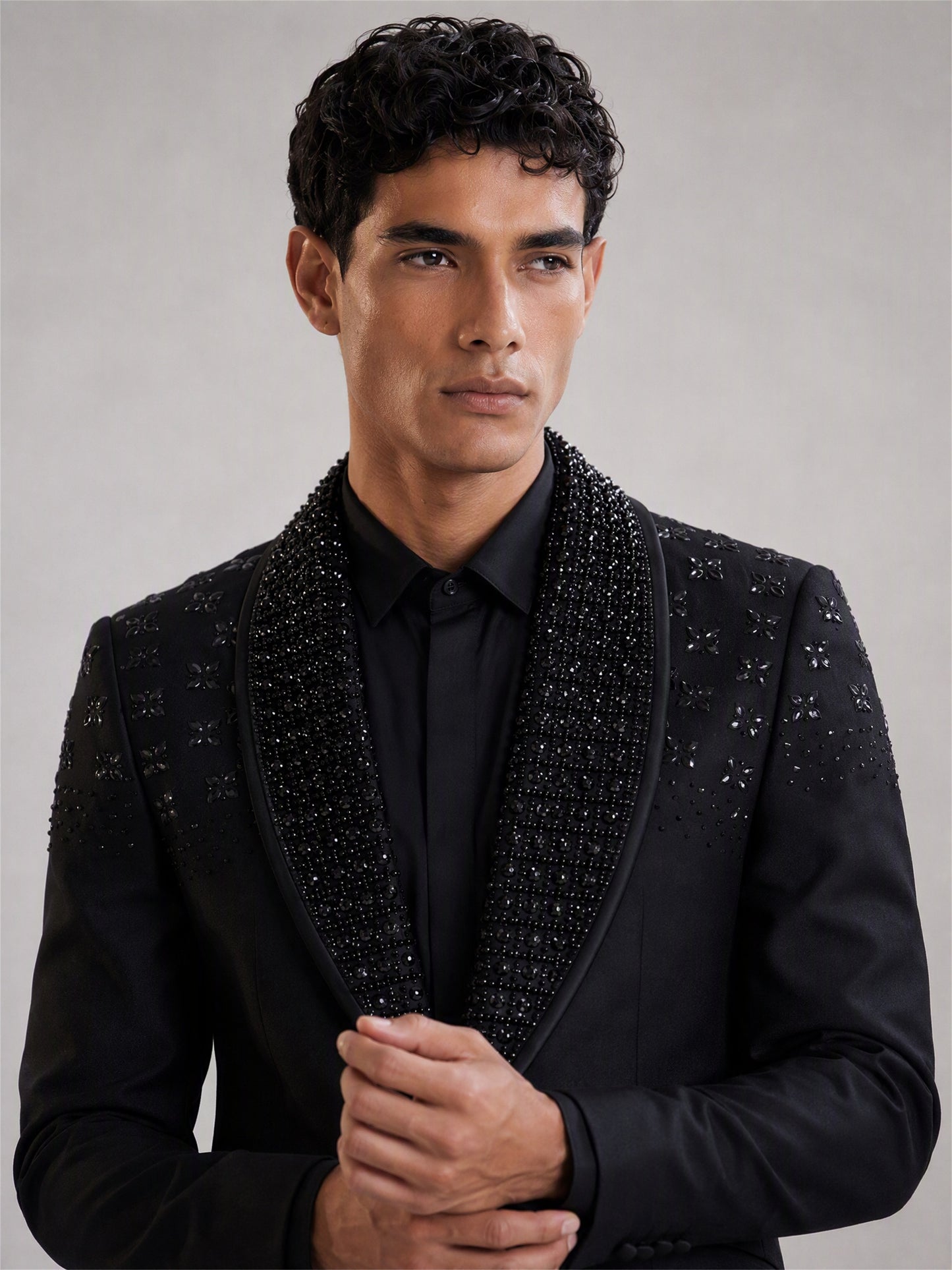 Savile black crystal shawl collar suit – full-length front view, hand in pocket showing floral crystal clusters on chest