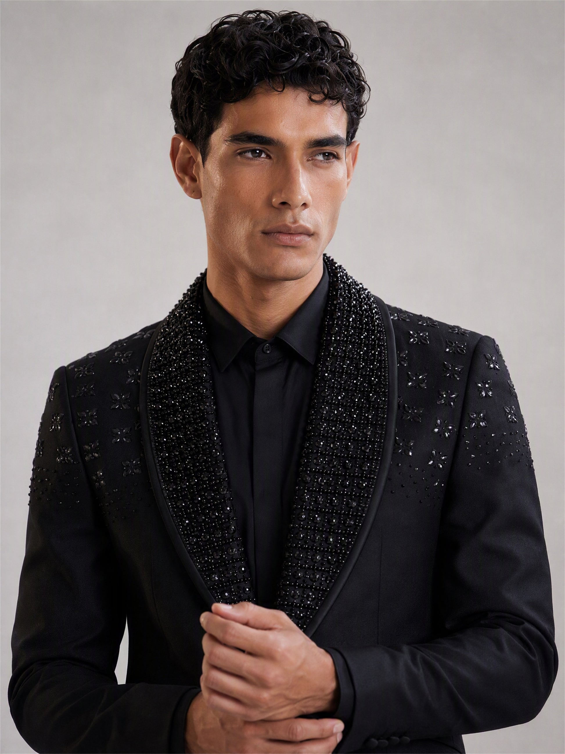 Savile black crystal shawl collar suit – full-length front view, hand in pocket showing floral crystal clusters on chest