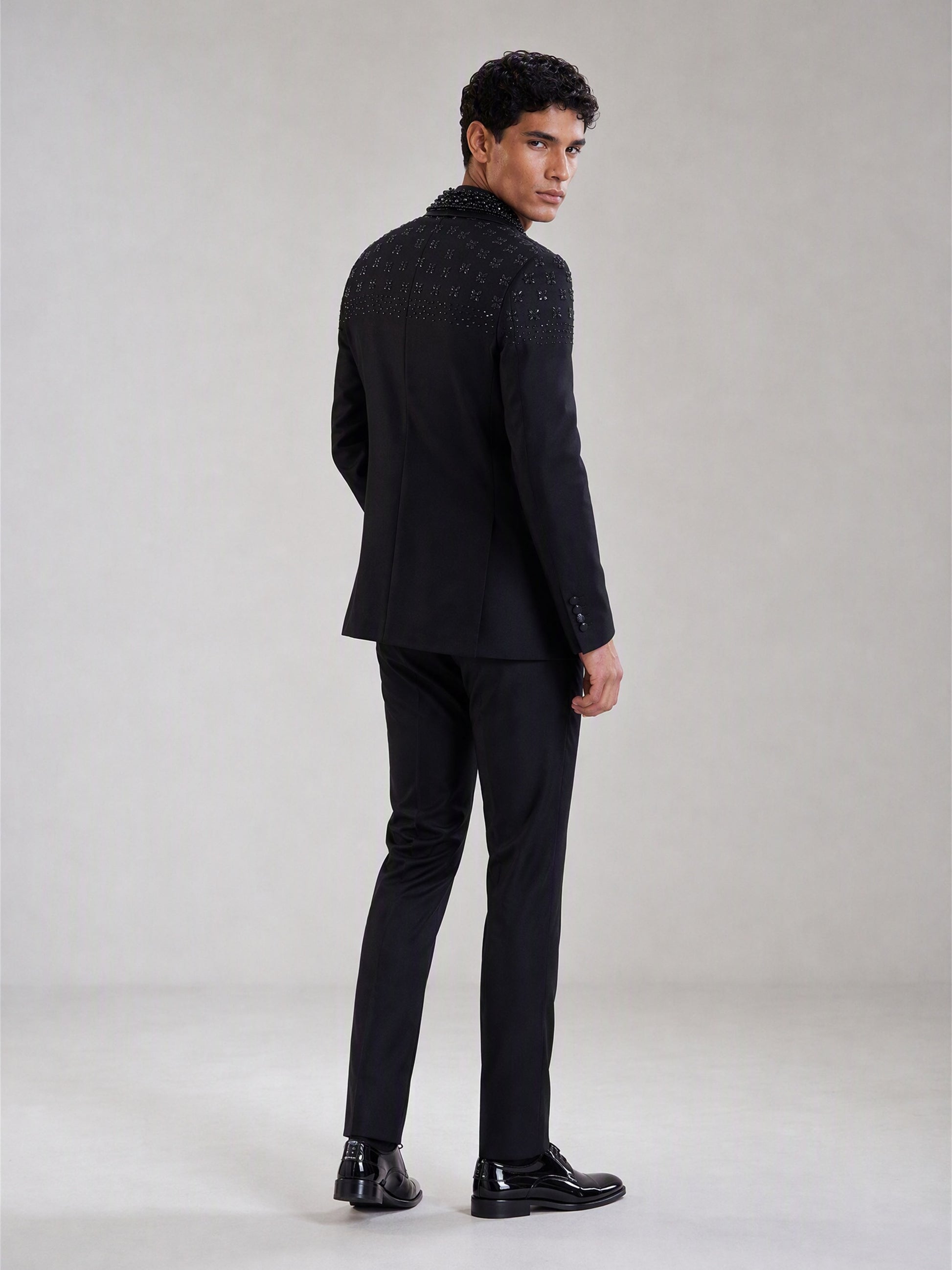 Savile black crystal shawl collar suit – close-up upper body, dense round brilliants and floral-cut gemstone medallions on shawl collar