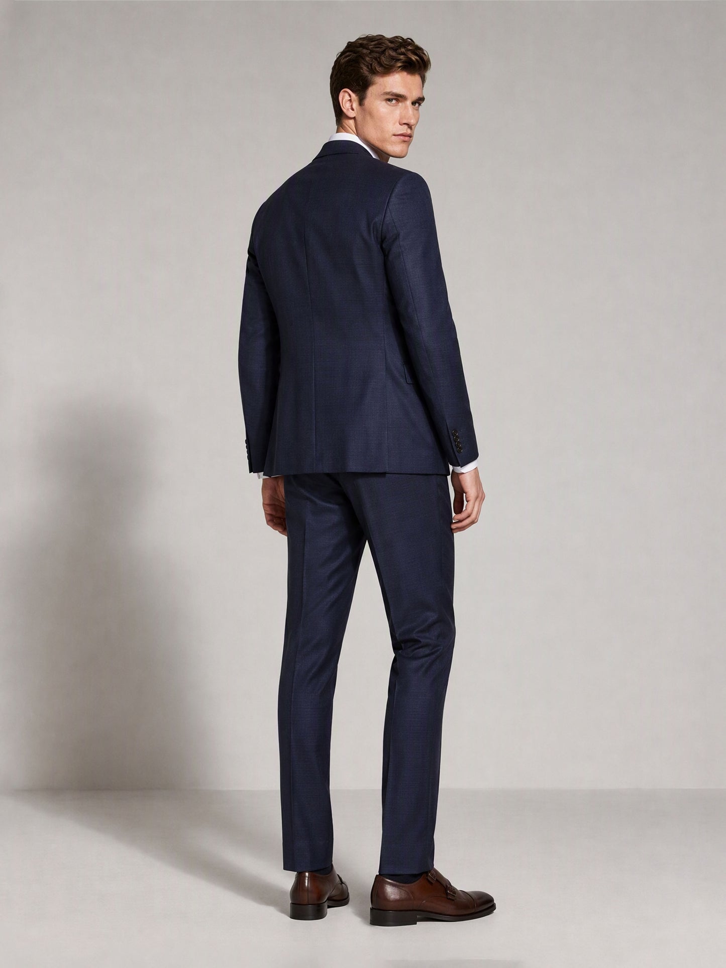 Savile navy blue business suit – close-up upper body, adjusting cuff showing notch lapel and pocket square detail