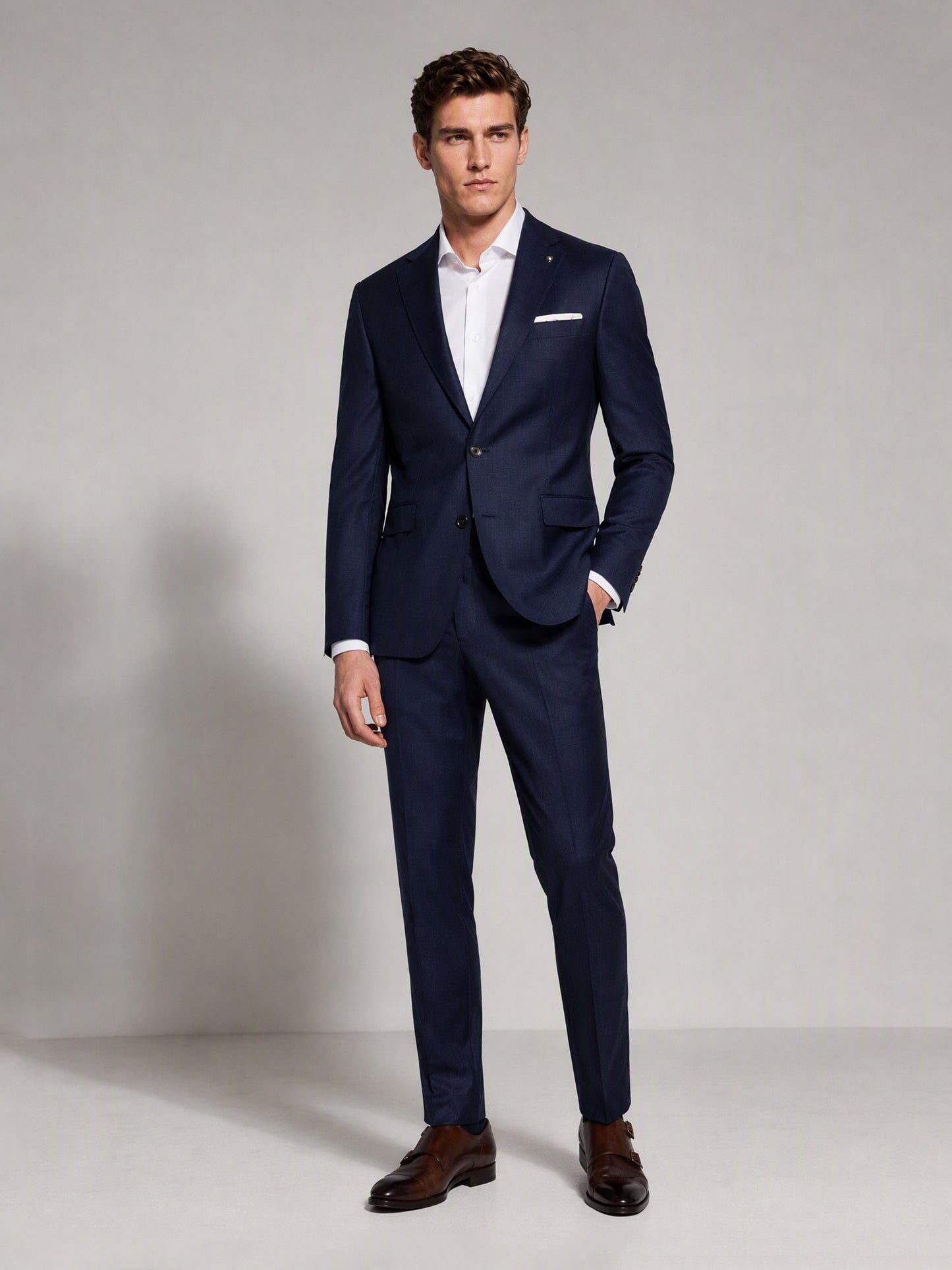 Savile navy blue business suit – full-length front view, hand in pocket showing slim fit silhouette