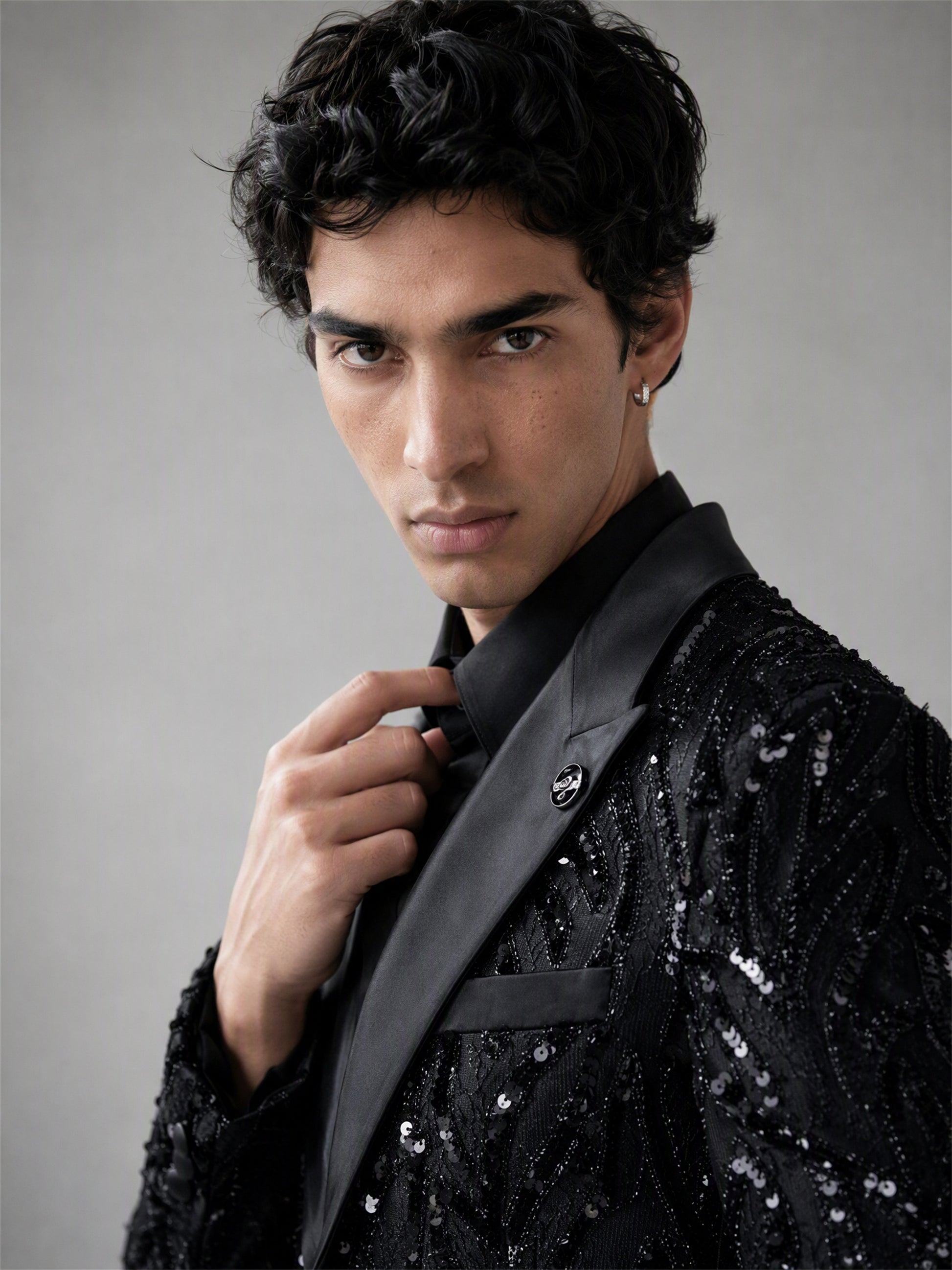 Savile black Art Deco sequin suit – full-length walking shot, silver geometric pattern and black satin peak lapels