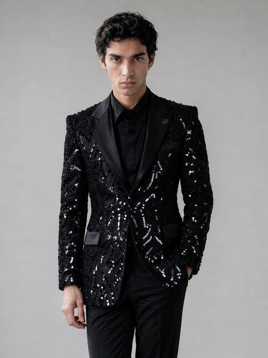 Savile black Art Deco sequin suit – close-up face and lapel, black medallion badge pin and satin peak lapel detail