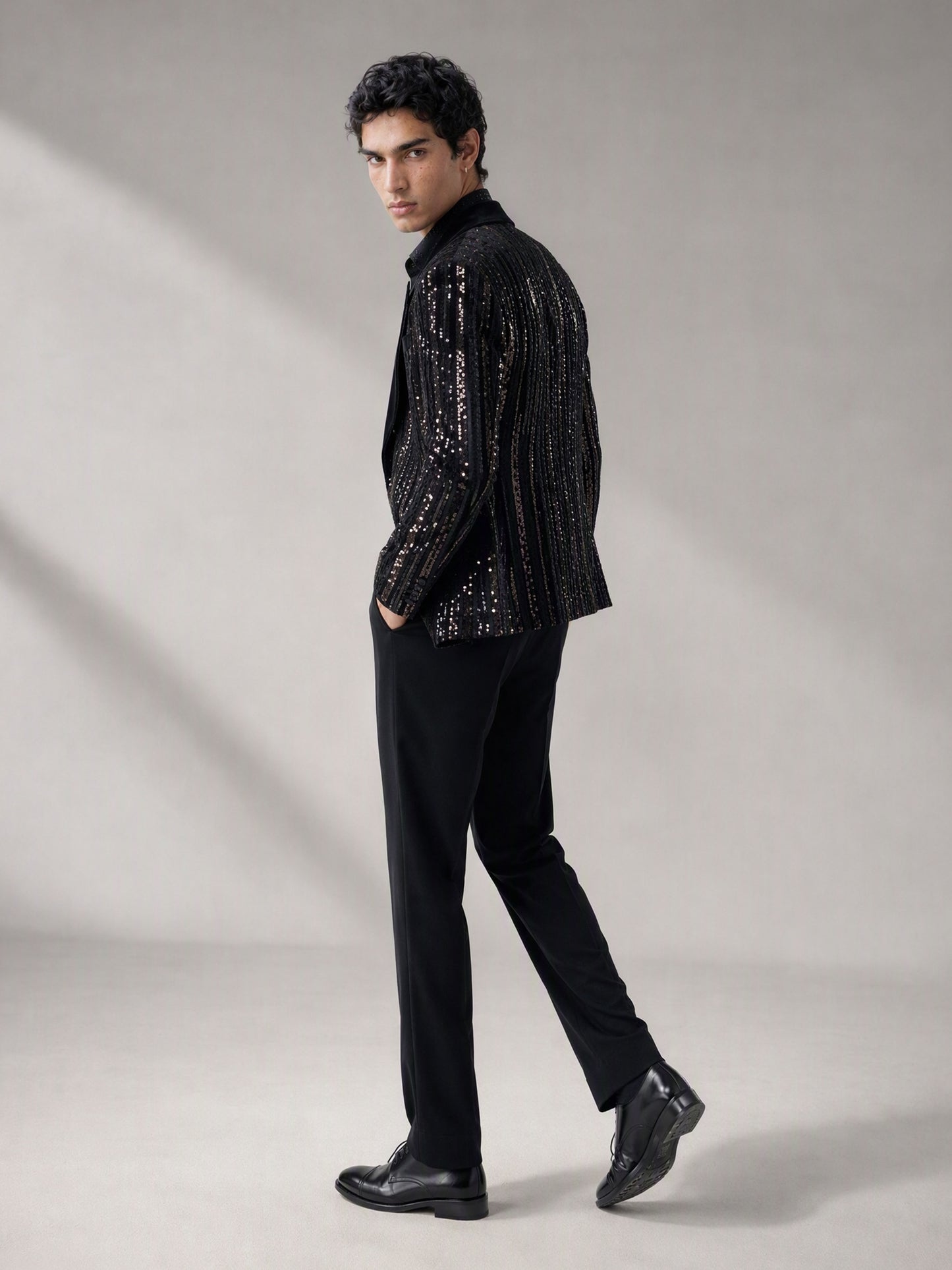 Savile black velvet sequin stripe suit – close-up face and upper body, silver sequin vertical stripes and black satin notch lapel detail