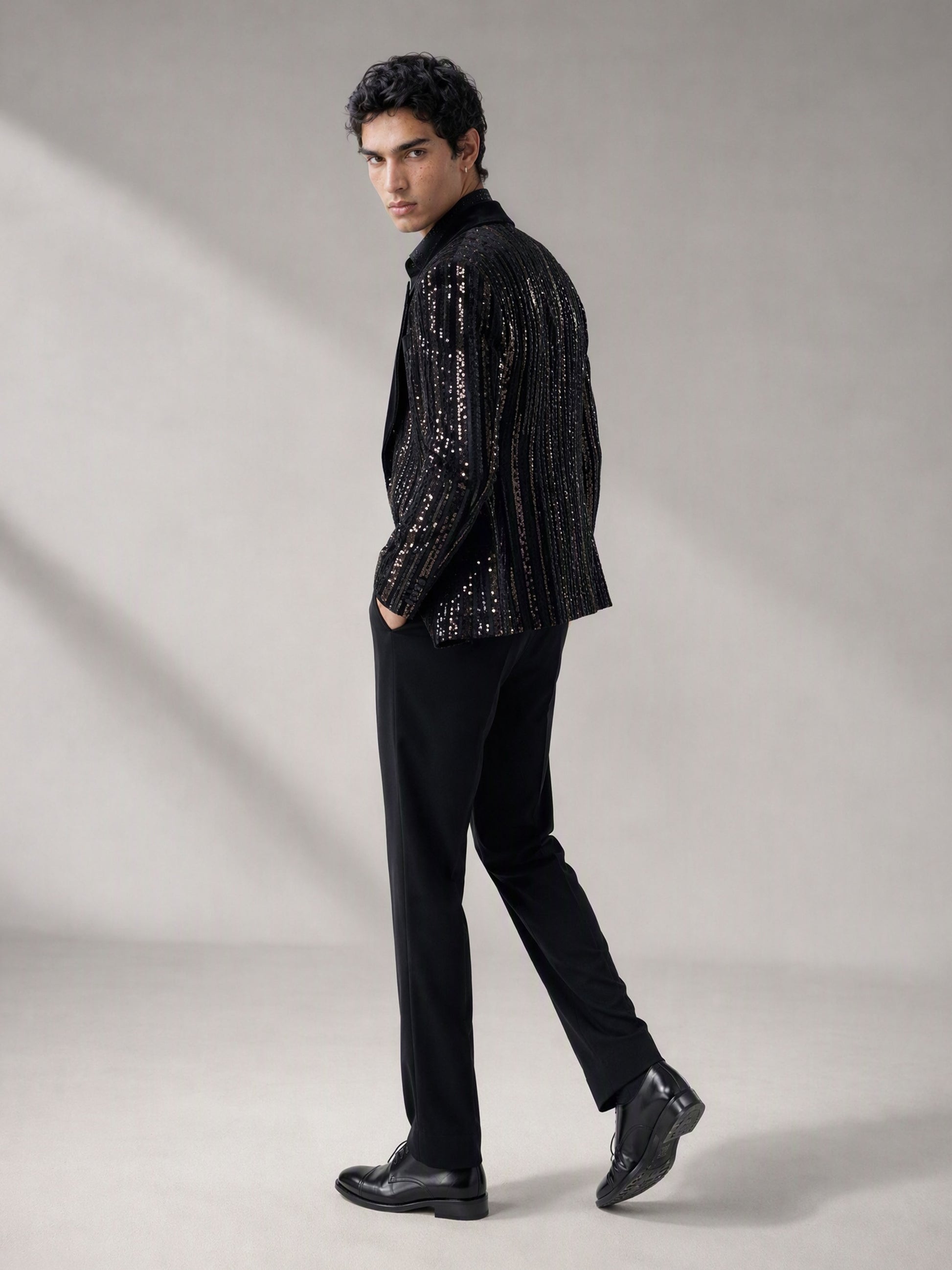 Savile black velvet sequin stripe suit – close-up face and upper body, silver sequin vertical stripes and black satin notch lapel detail