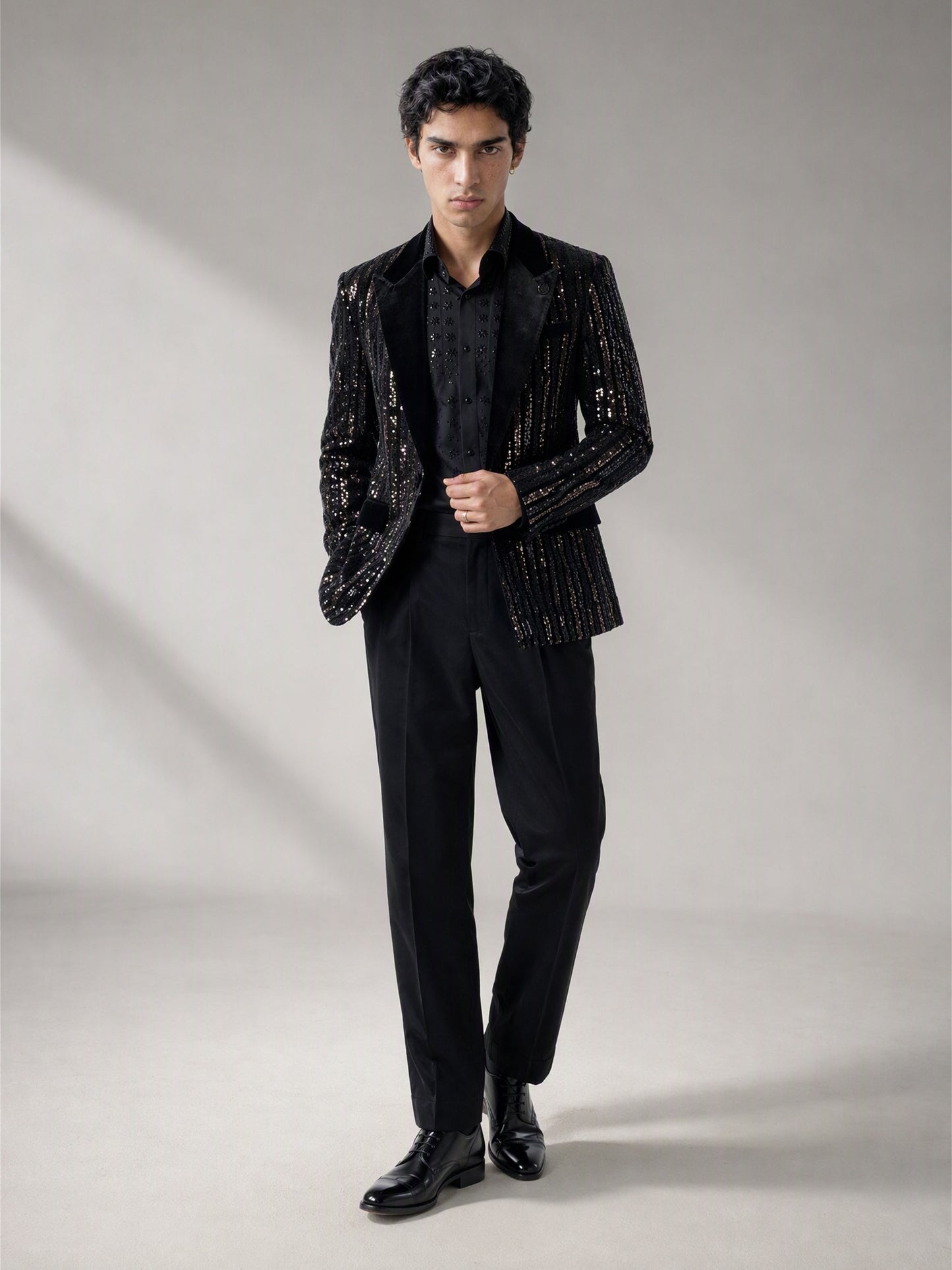 Savile black velvet sequin stripe suit – three-quarter side view, silver sequin stripes catching light and floral-beaded shirt detail