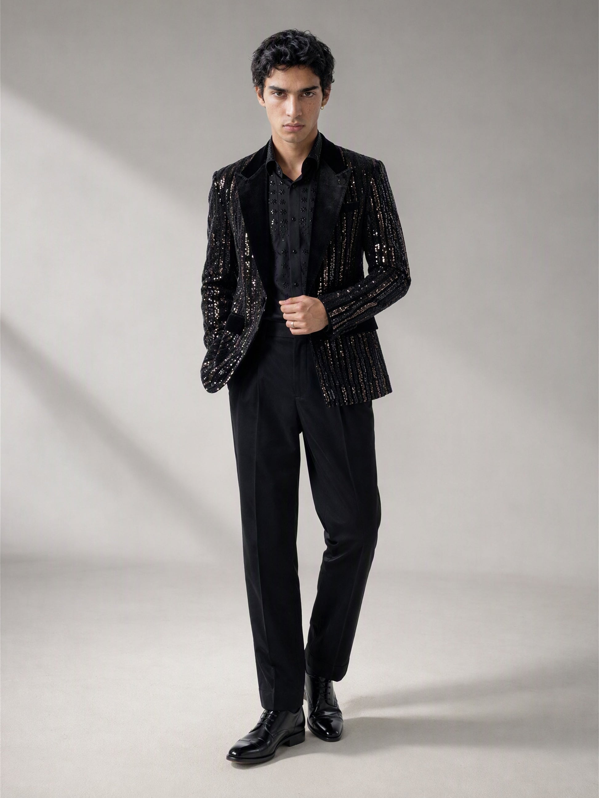 Savile black velvet sequin stripe suit – three-quarter side view, silver sequin stripes catching light and floral-beaded shirt detail