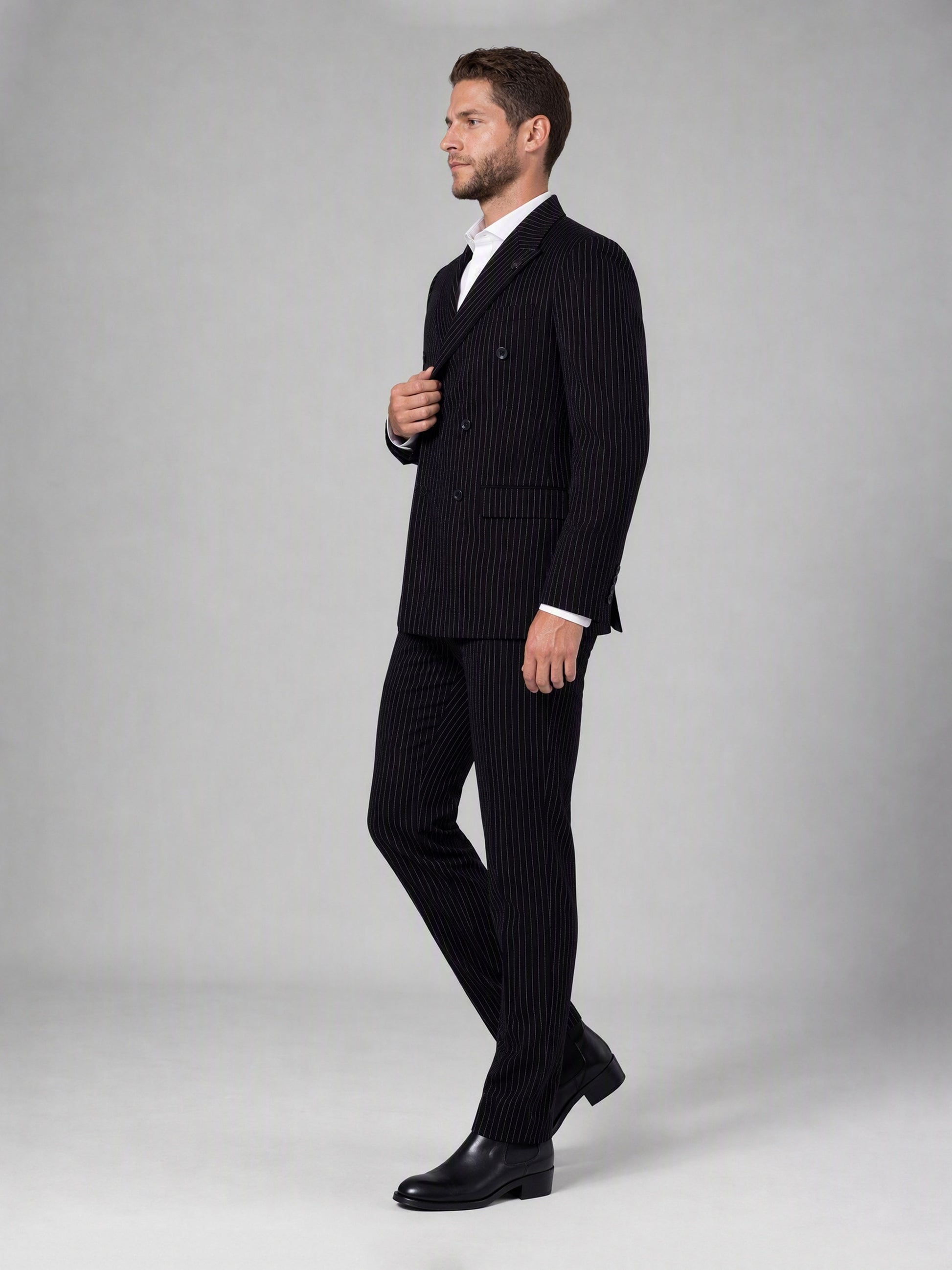 Savile black velvet chalk stripe double-breasted suit – close-up upper body, wide peak lapels, badge pin and chalk stripe texture detail