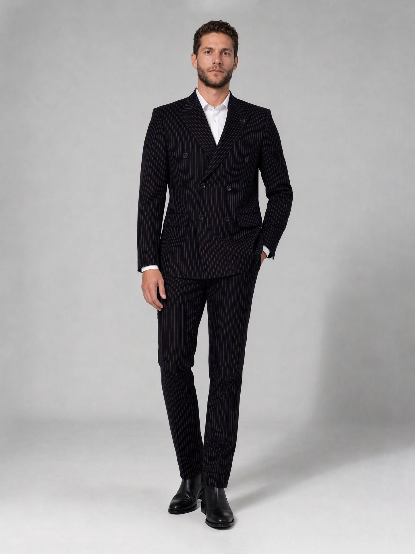 Savile black velvet chalk stripe double-breasted suit – full-length front view, hand in pocket showing complete chalk stripe silhouette