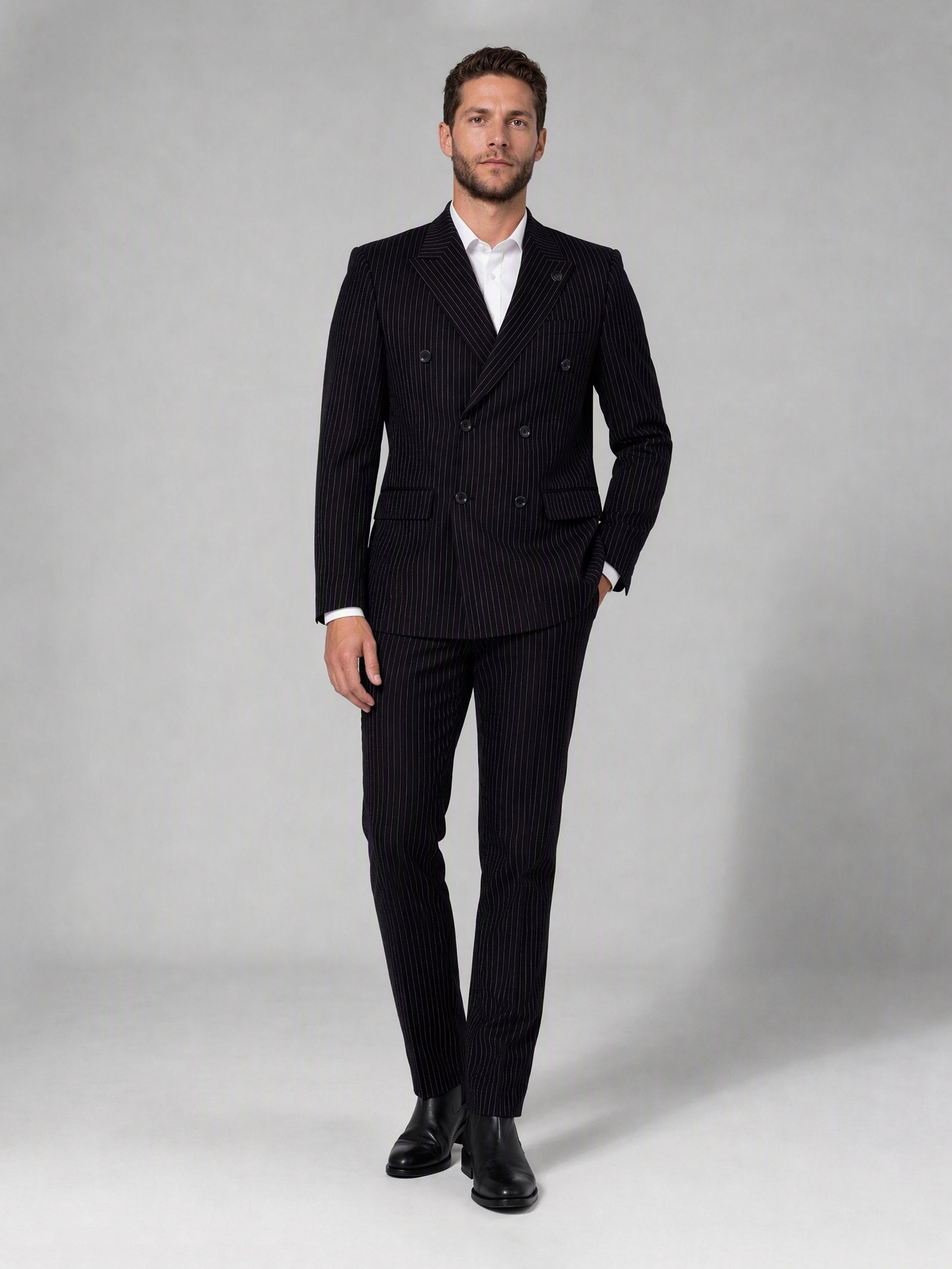Savile black velvet chalk stripe double-breasted suit – full-length front view, hand in pocket showing complete chalk stripe silhouette