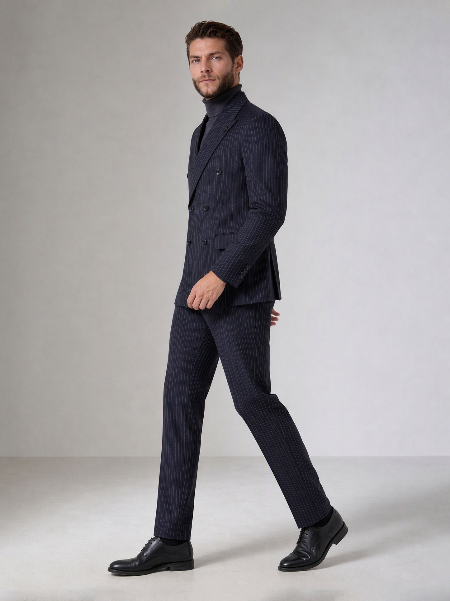 Savile navy blue chalk stripe double-breasted suit – full-length front view, standing straight showing wide peak lapels and 6-button closure with grey turtleneck