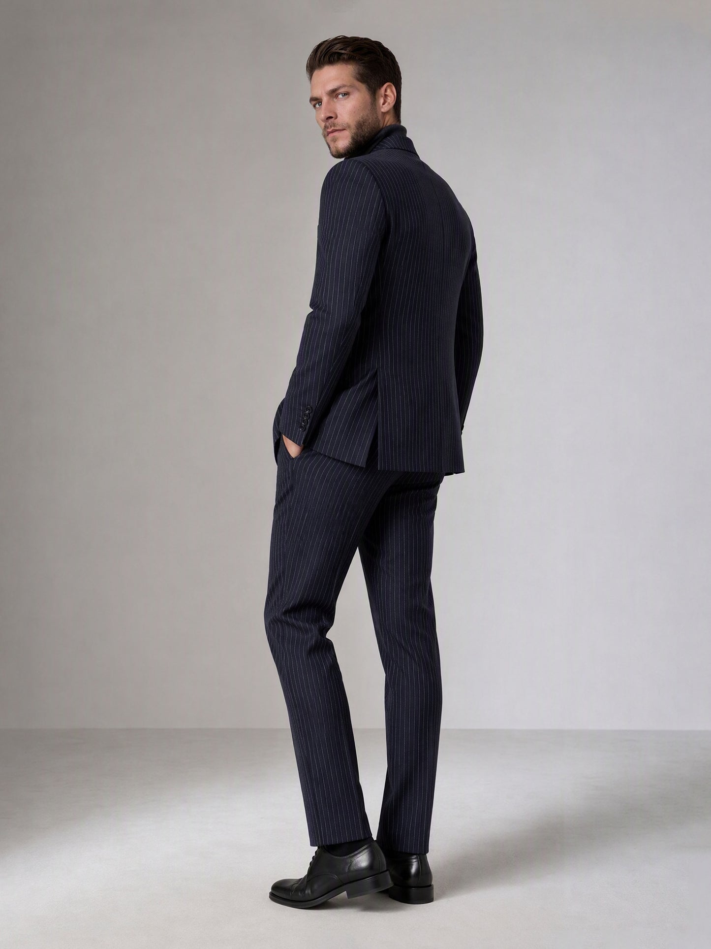 Savile navy blue chalk stripe double-breasted suit – full-length side walking shot showing chalk stripe trousers and black brogue oxfords