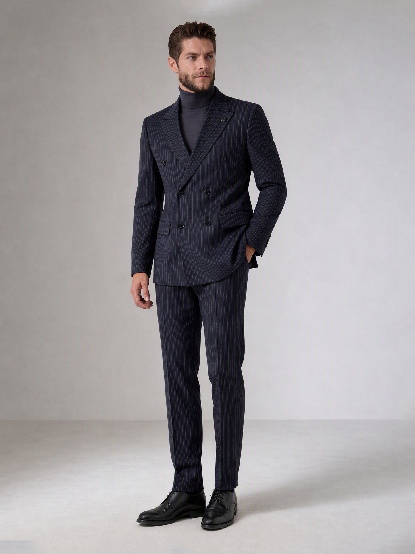 Savile navy blue chalk stripe double-breasted suit – back view showing center vent, chalk stripe pattern and tapered trouser silhouette