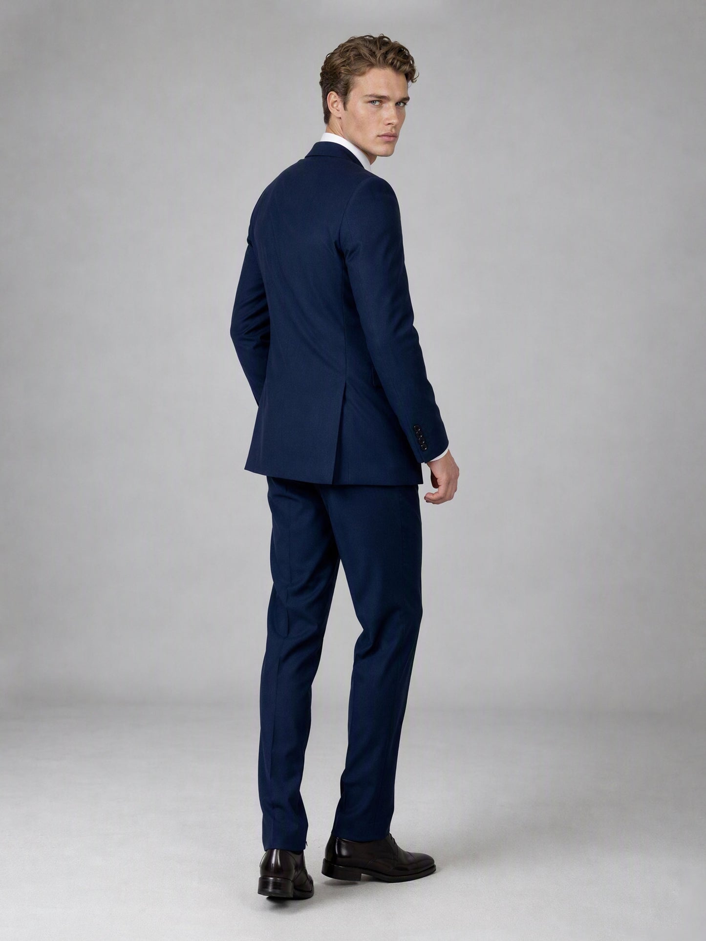 Savile deep navy double-breasted suit – full-length front view, standing straight showing wide peak lapels, navy tie and tonal navy buttons