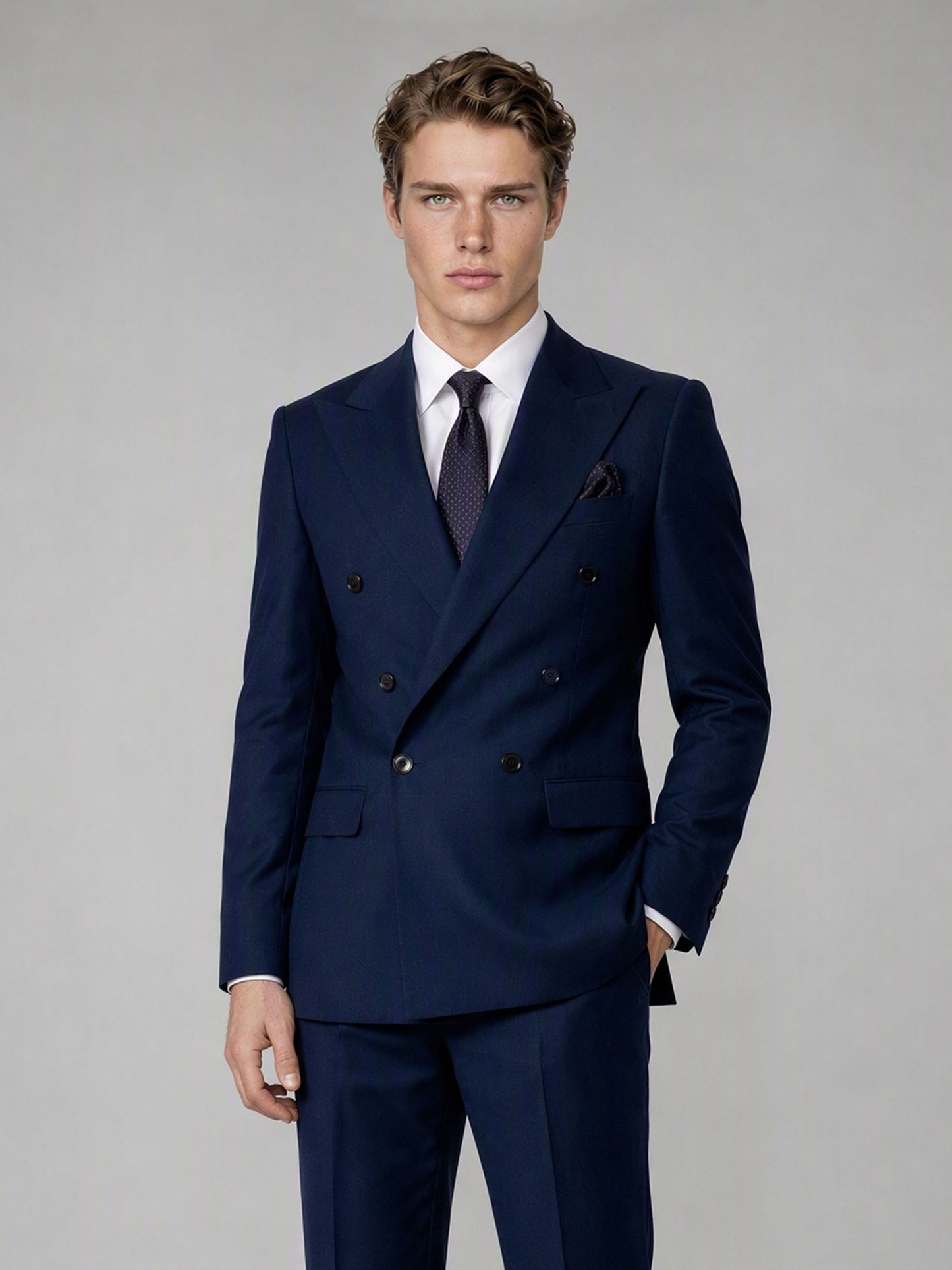 Savile deep navy double-breasted suit – close-up upper body, adjusting cuff showing peak lapel structure, navy pocket square and dot-pattern tie