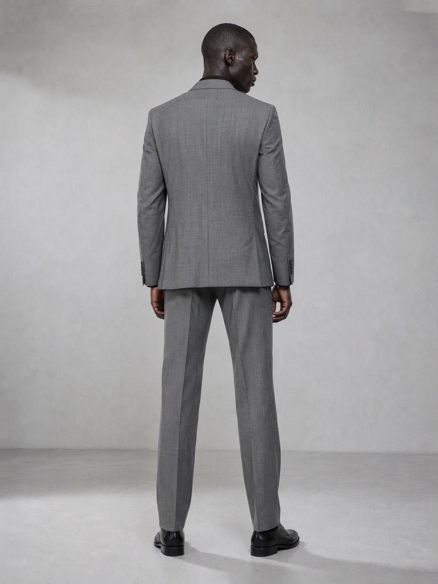 Savile grey wool blend suit – full-length front view, hand in pocket showing notch lapel and tapered trouser silhouette