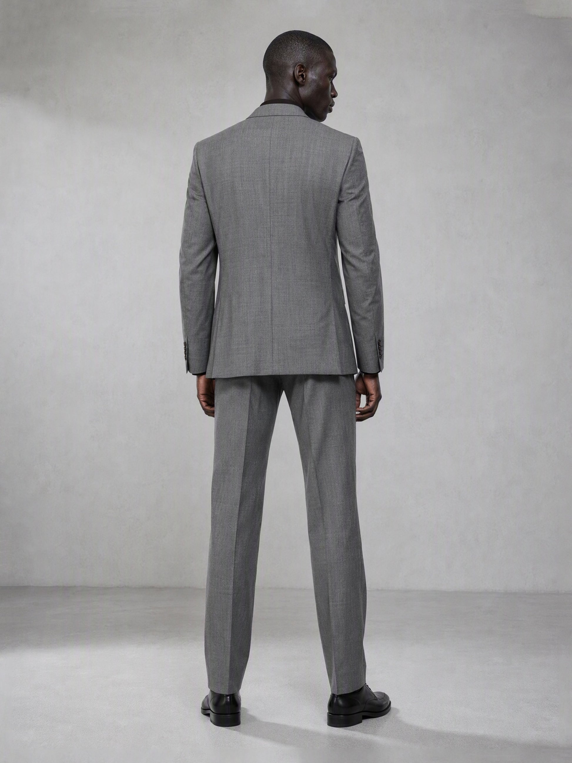 Savile grey wool blend suit – full-length front view, hand in pocket showing notch lapel and tapered trouser silhouette