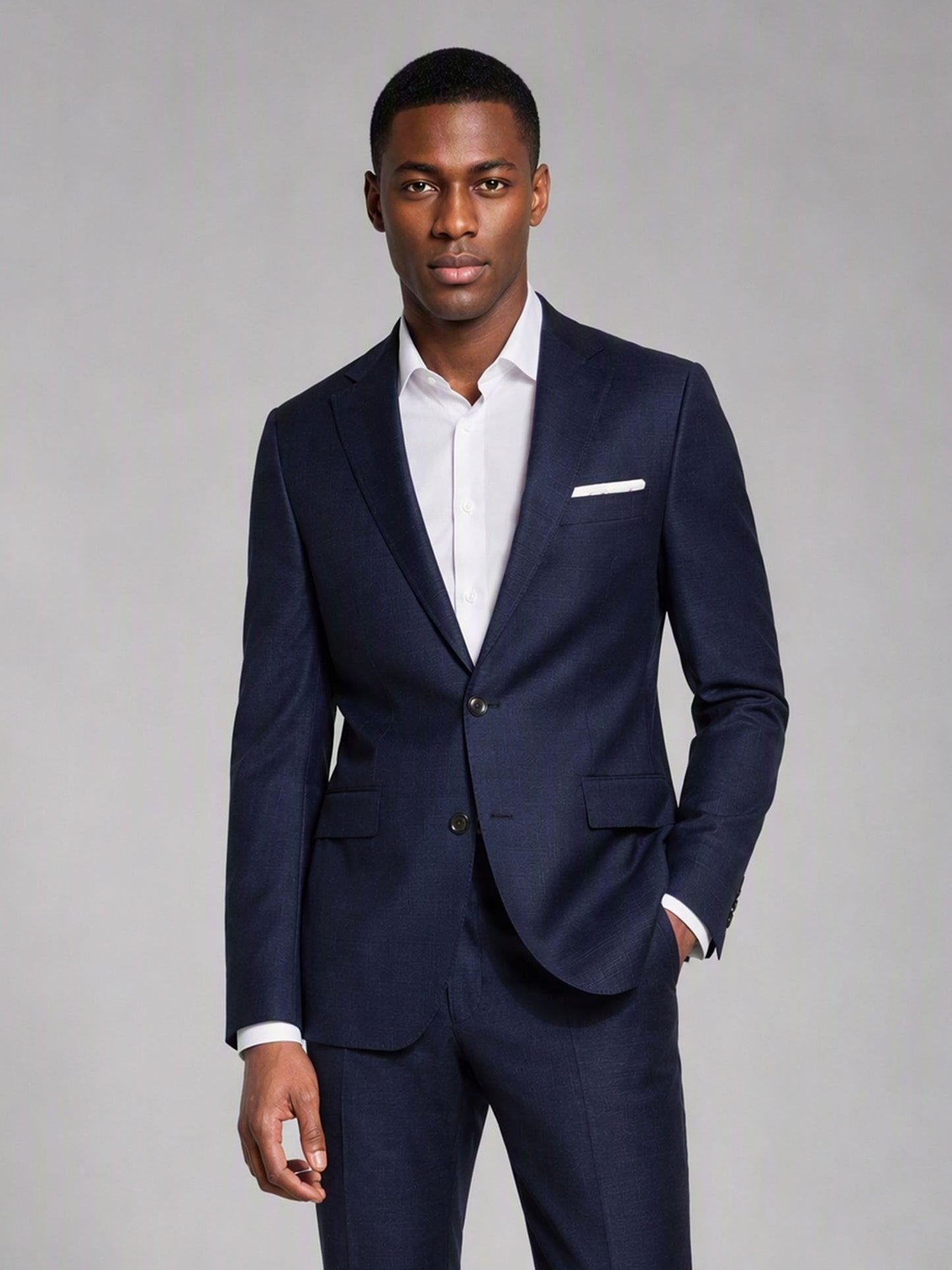 Savile deep navy slim fit suit – three-quarter back walking shot showing center vent, structured shoulder and tapered trouser with brown monk-strap shoes