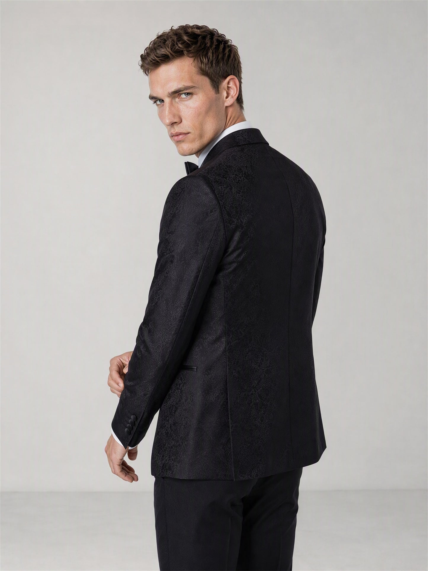 Men's Black Jacquard Peak Lapel Tuxedo Suit – Back View Over-Shoulder Pose