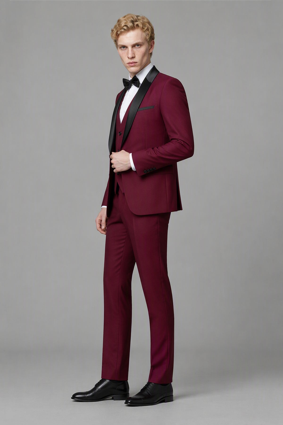 Savile Burgundy 3-Piece Tuxedo Set – Three-quarter front view, model adjusting jacket showing natural drape