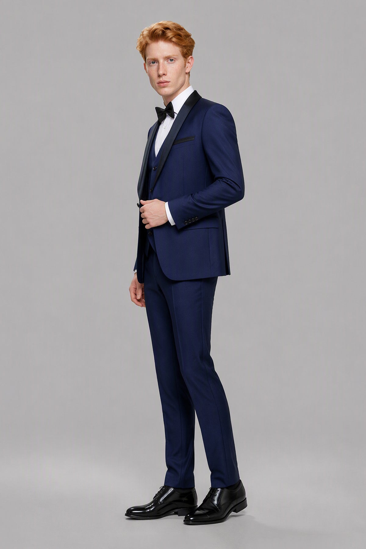 Savile Navy Blue 3-Piece Tuxedo Set – Three-quarter side view, model adjusting jacket showing lapel and fit detail