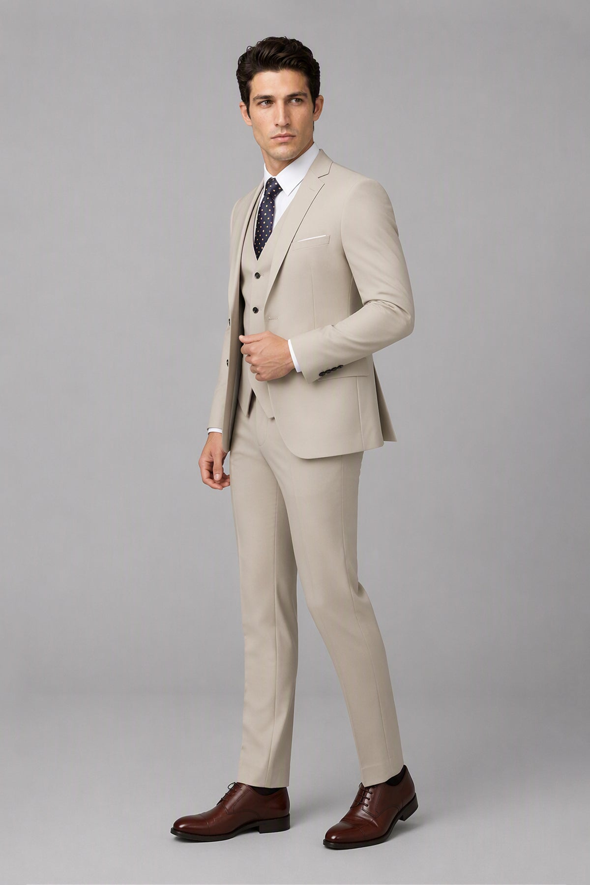Savile Beige 3-Piece Suit Set – Three-quarter side view, model adjusting jacket showing lapel and fit detail