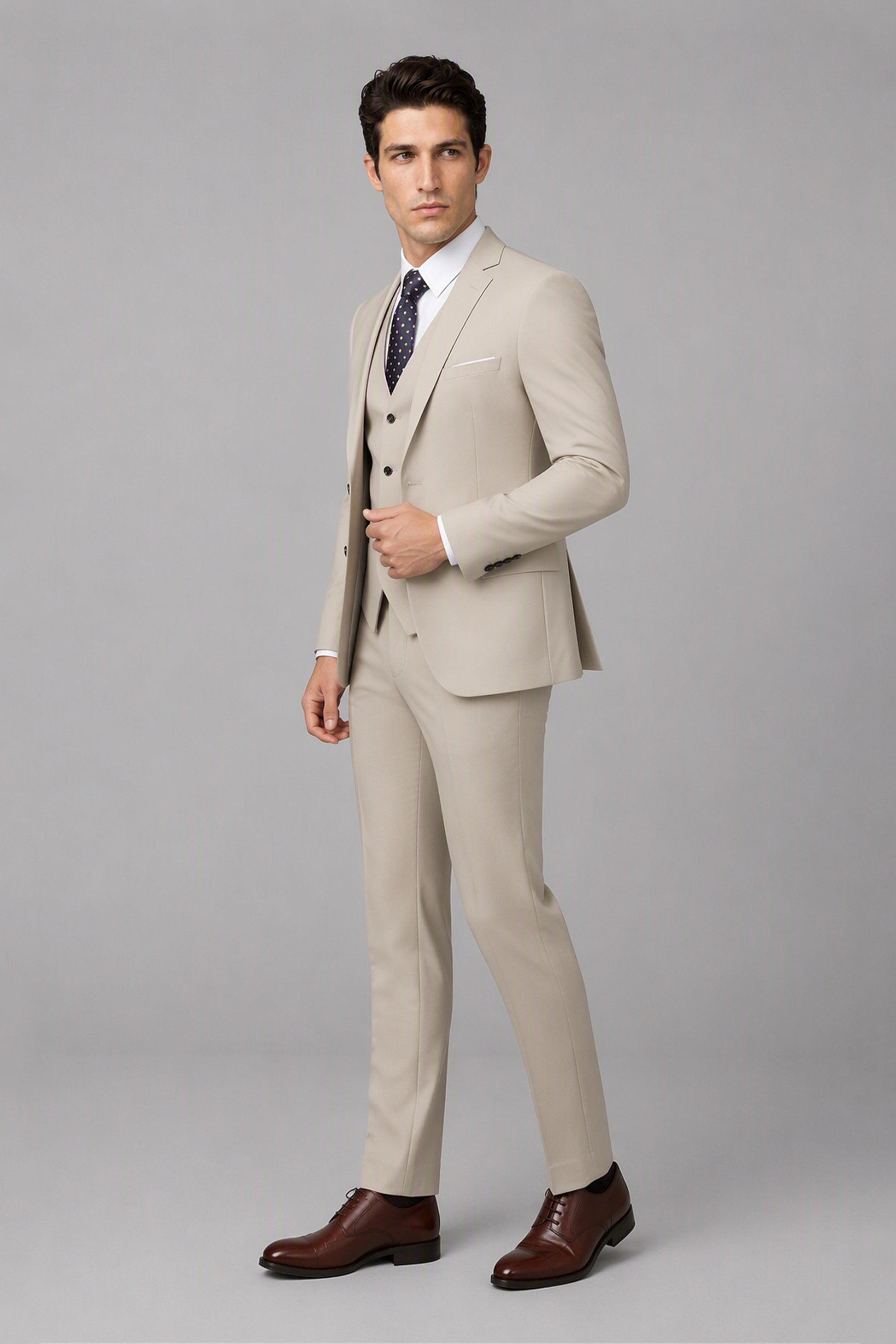 Savile Beige 3-Piece Suit Set – Three-quarter side view, model adjusting jacket showing lapel and fit detail