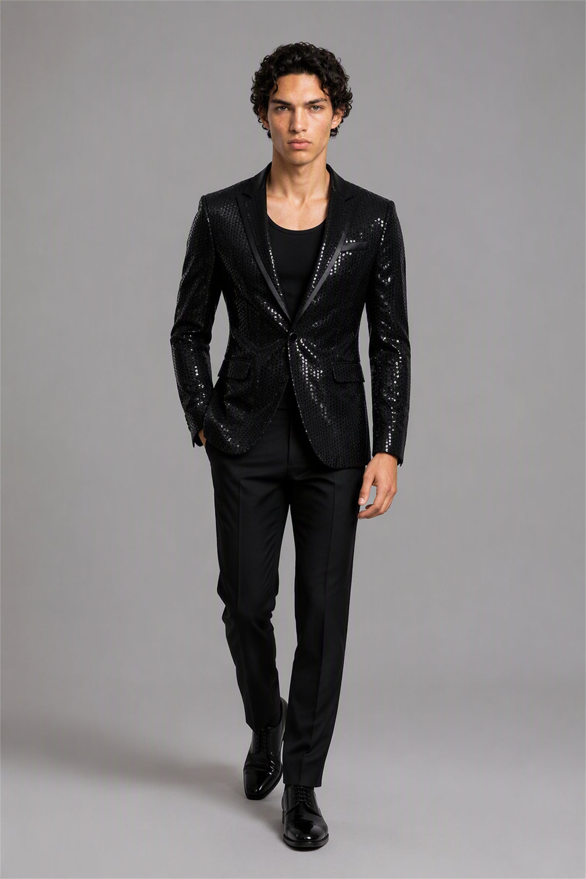 Savile Black Sequin Tuxedo Jacket – Half-body front close-up showing all-over black sequin embellishment and black satin peak lapel detail