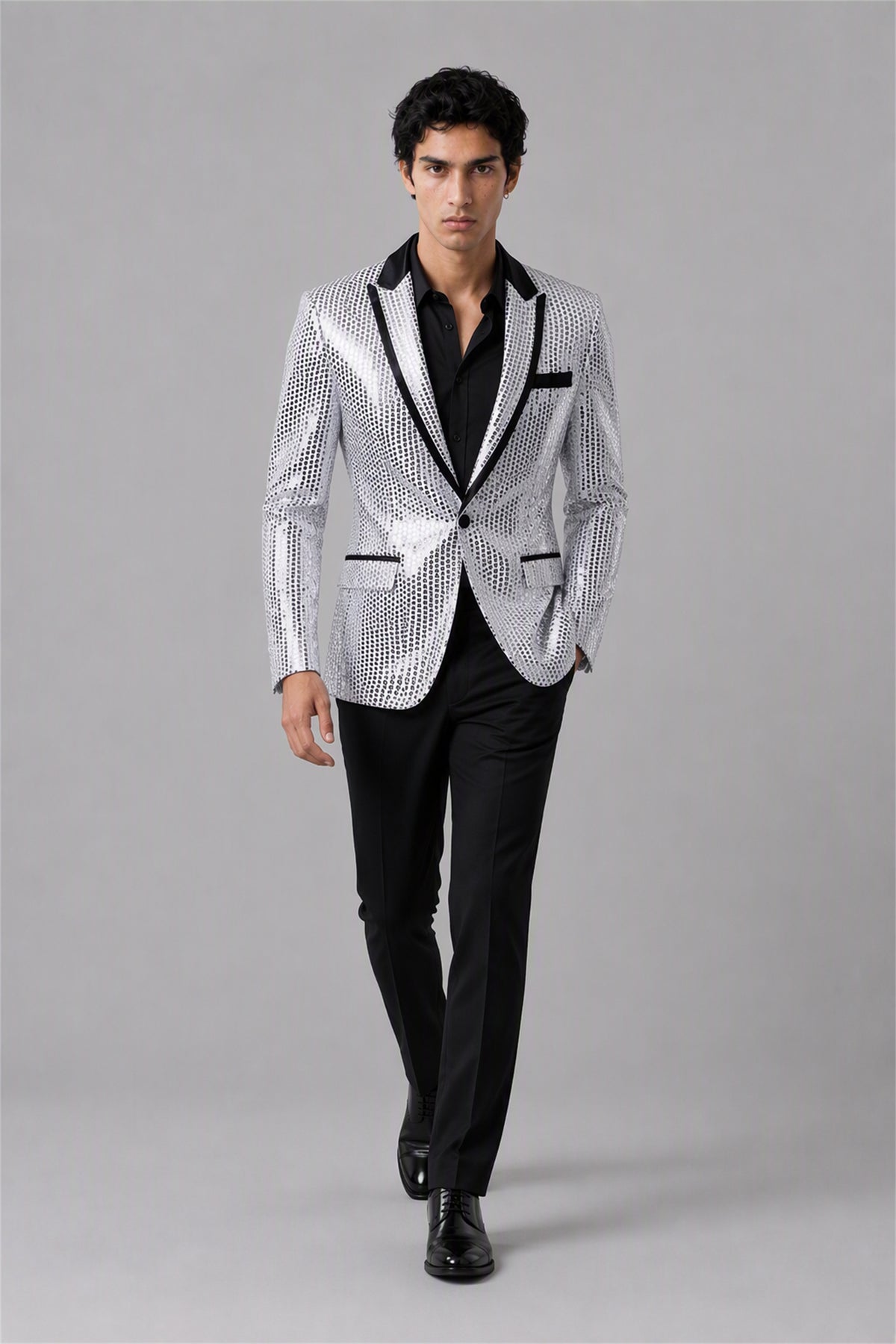Savile Silver Sequin Tuxedo Jacket – Full front standing view, hand in pocket showing slim-fit silhouette and silver sequin embellishment with black satin lapel