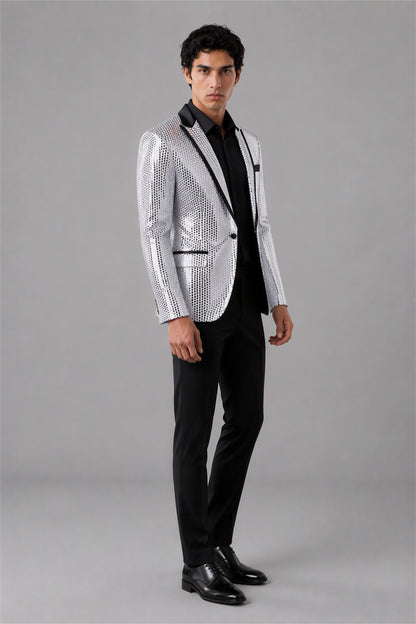 Savile Silver Sequin Tuxedo Jacket – Three-quarter front view, model holding jacket showing silver sequin texture and black satin lapel detail